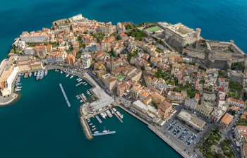 Storslået fugleperspektiv over den historiske italienske kystby Gaeta ved Middelhavet med gammel fæstning, havn med lystbåde og farverig bebyggelse i Lazio