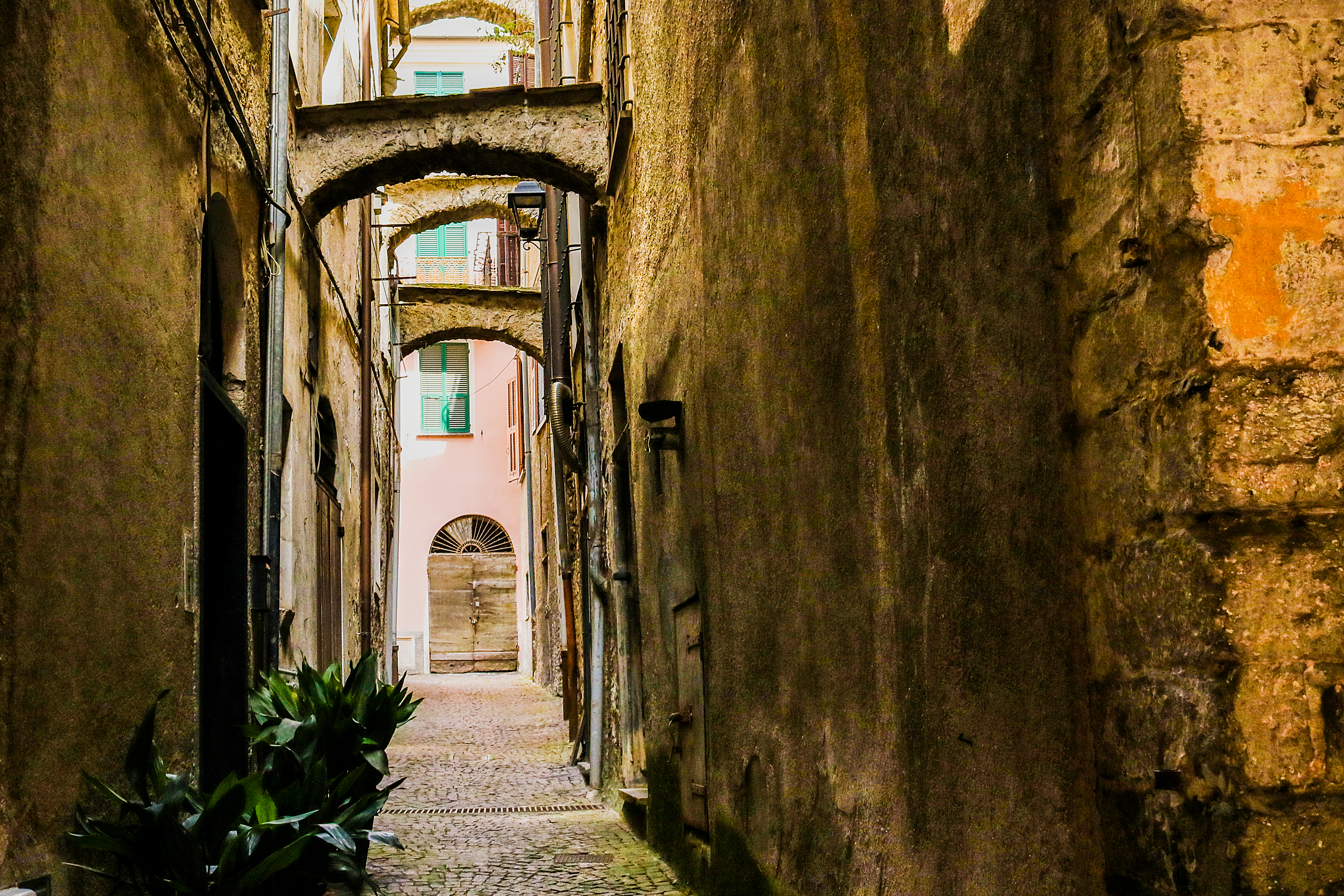 Romantisk smal gyde med historiske stenarkader i den lille by Pieve di Teco i det nordlige Italien