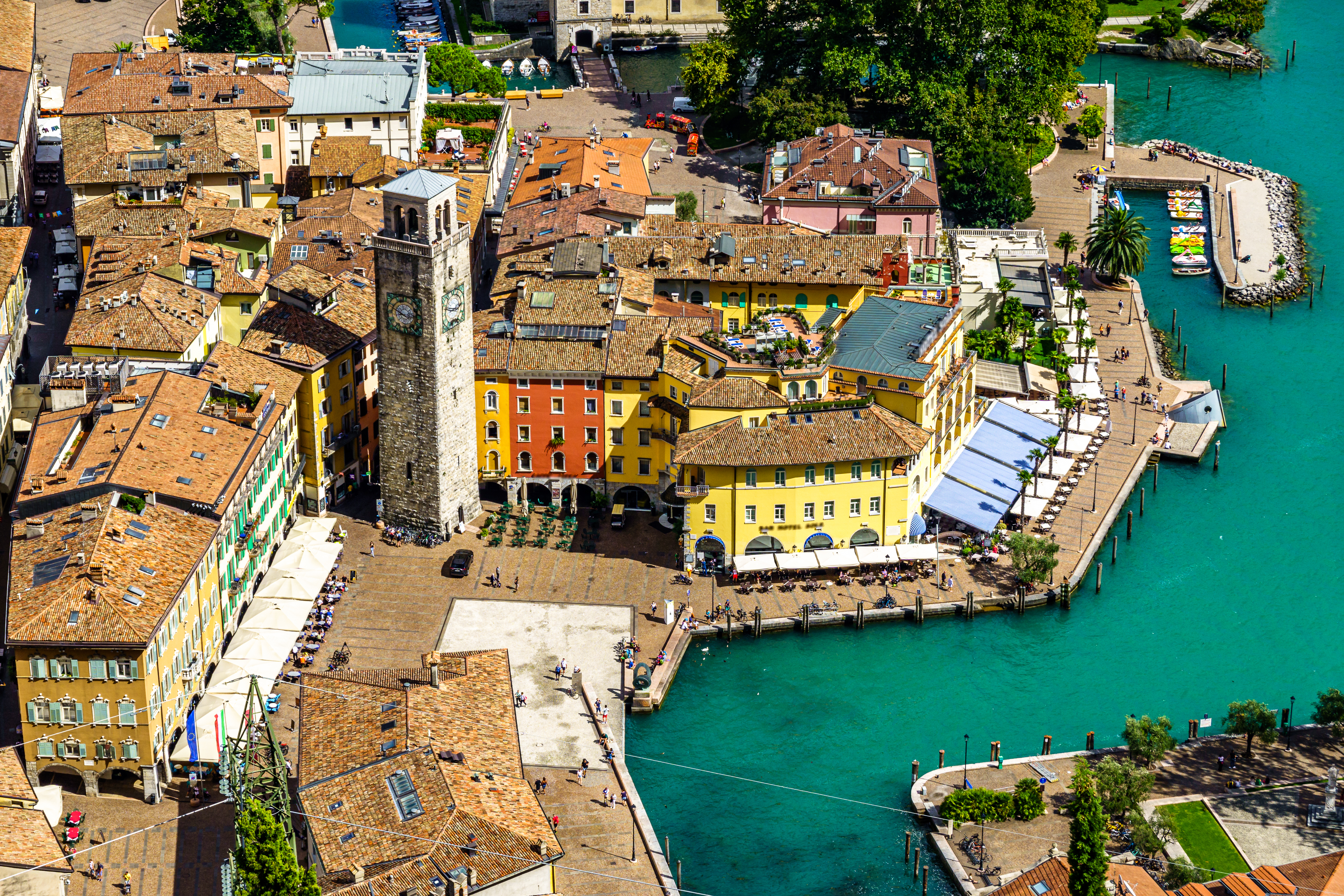 Smuk panoramaudsigt over Riva del Garda med orange tage og krystalklart vand ved Gardasøen