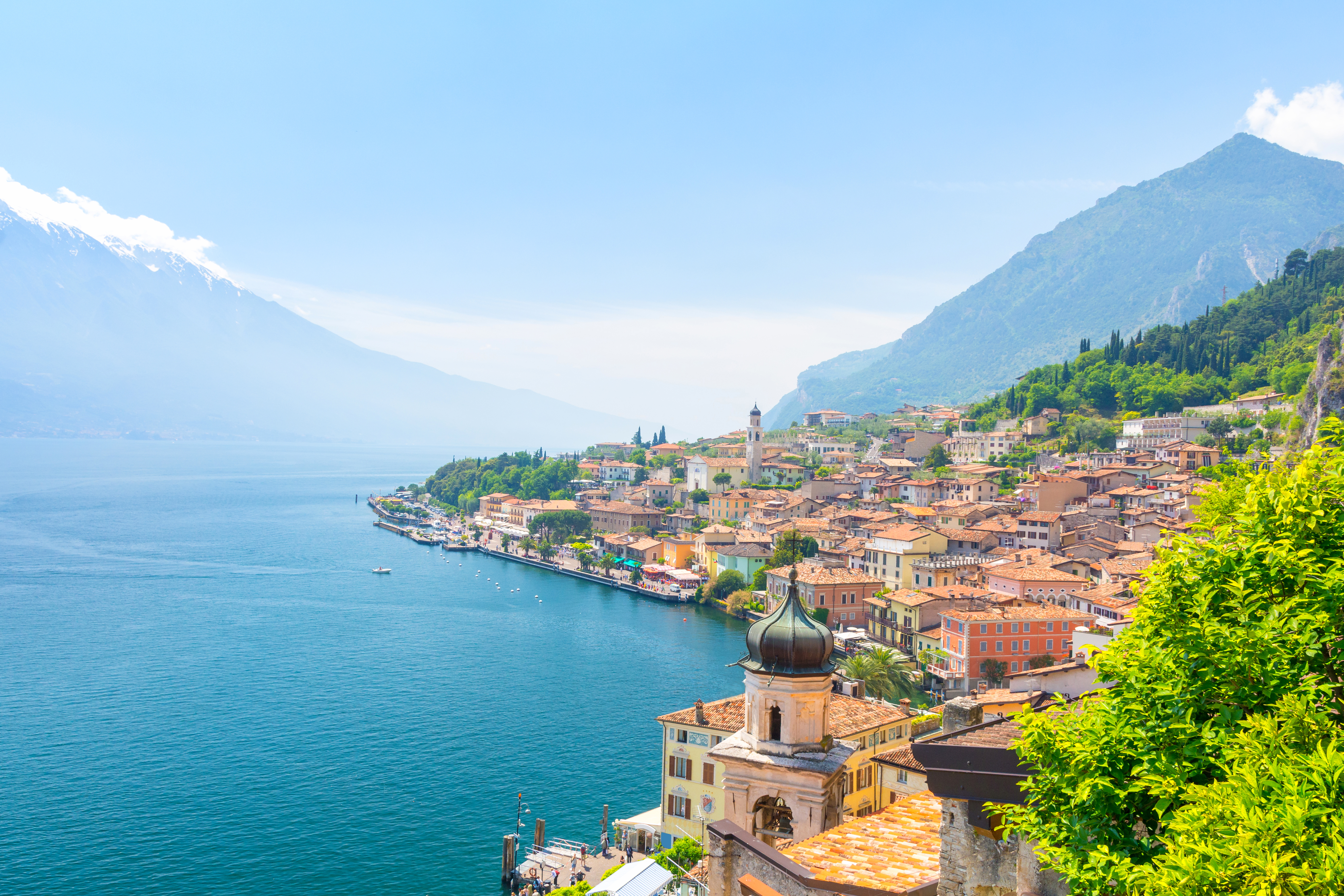 Idyllisk udsigt over Limone sul Garda ved Gardasøen med charmerende italiensk arkitektur og sneklædte alper i horisonten