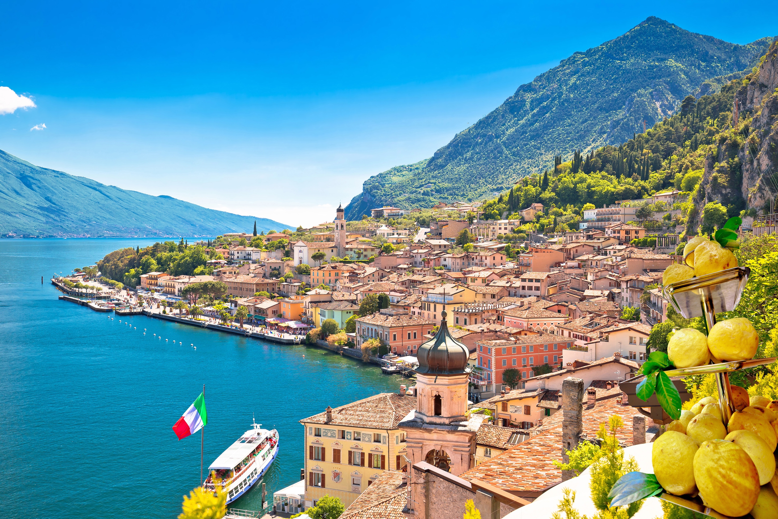 Idyllisk udsigt over Limone sul Garda ved Gardasøen med farverige huse, kirketårn og maleriske bjerge i Lombardiet