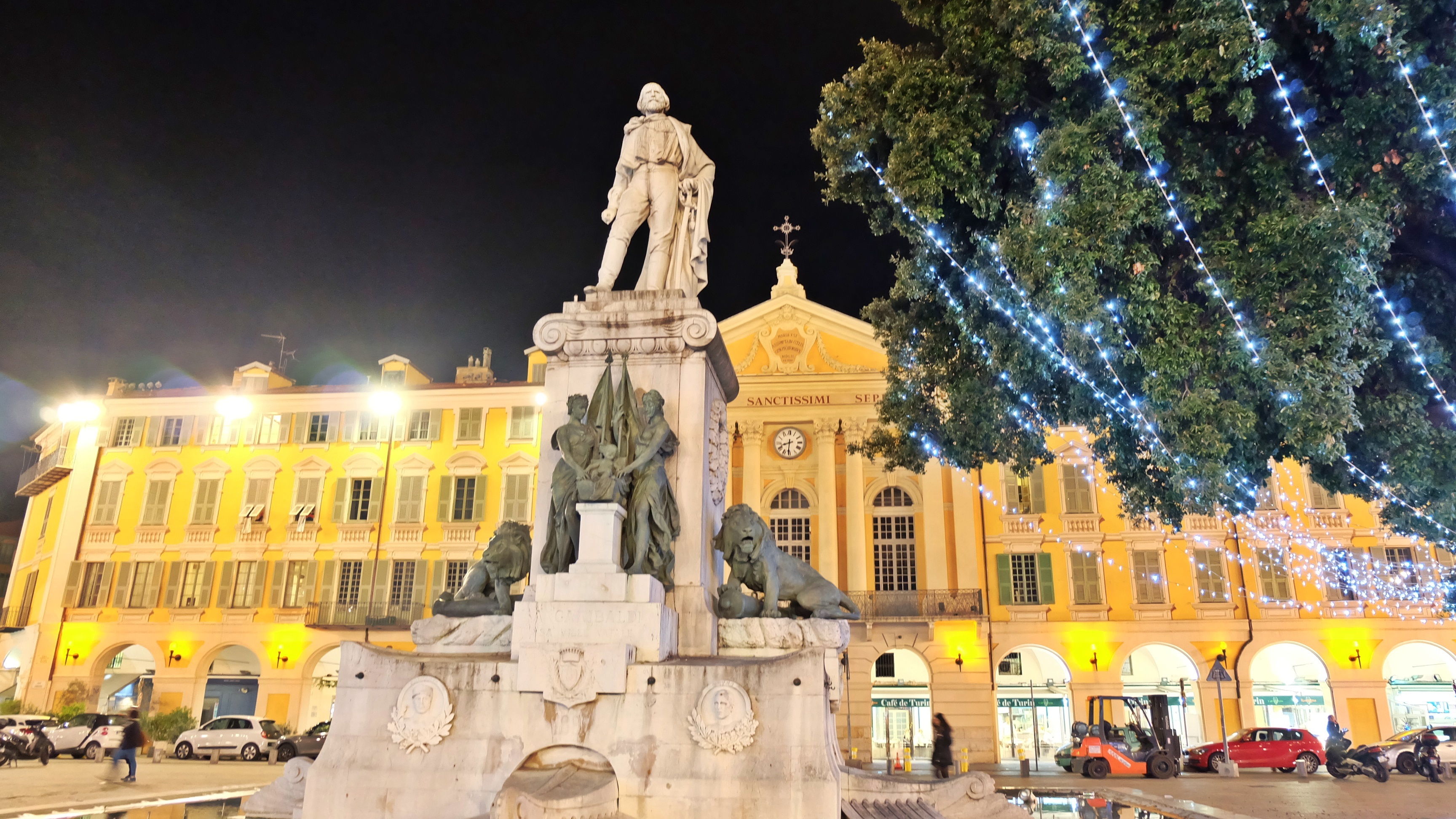 Place Garibaldi i Nice, Frankrig, pyntet til jul med tindrende lys og den klassiske Garibaldi-statue som midtpunkt, omgivet af arkitektoniske perler i varmt aftenlys