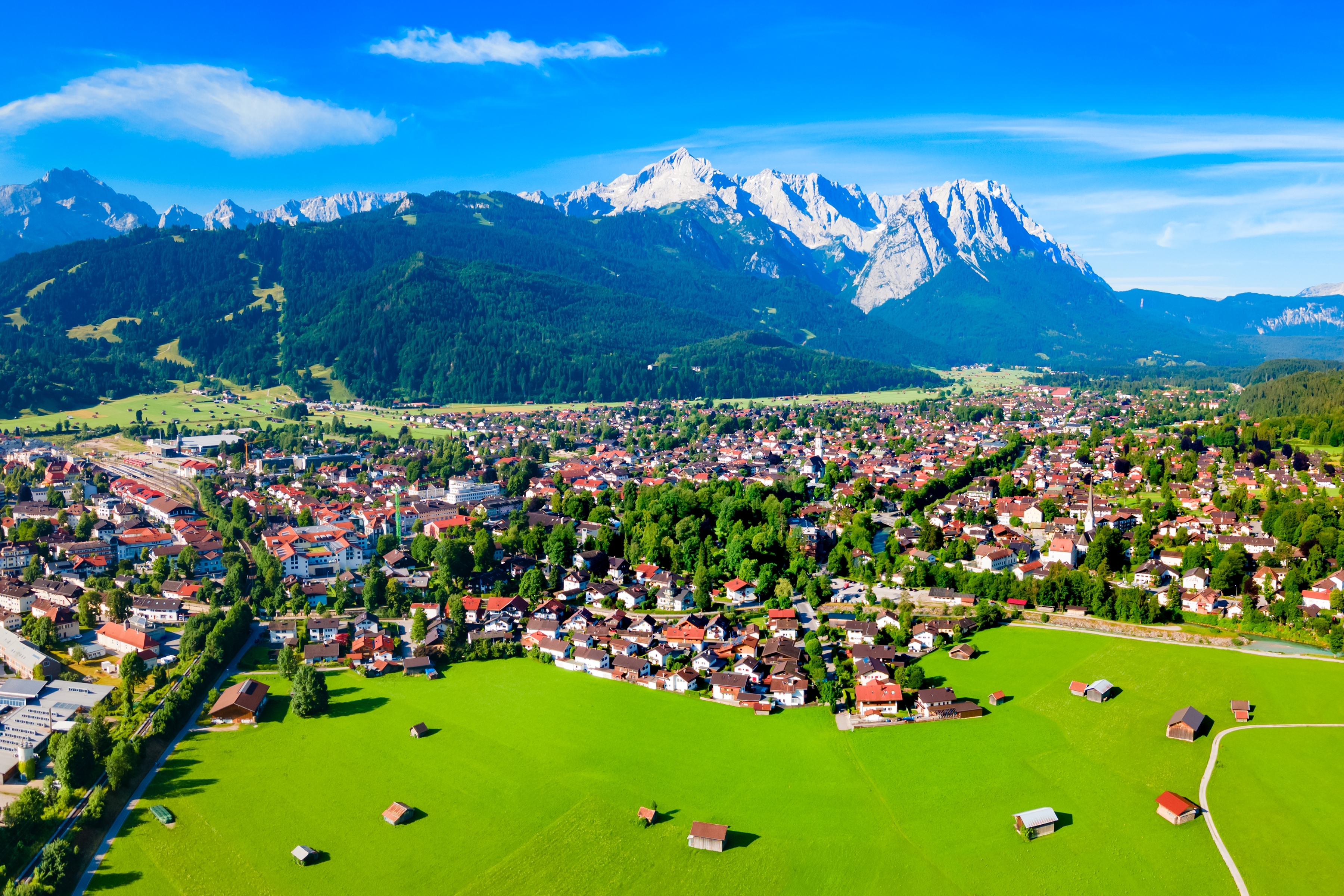 Fugleperspektiv over den idylliske alpeby Garmisch-Partenkirchen med Zugspitze i baggrunden, Bayern