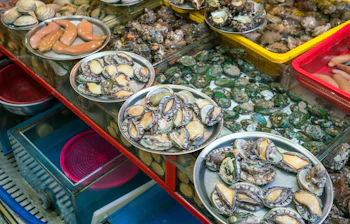 Kulinarisk oplevelse med friske skaldyr og muslinger på det livlige fiskemarked i Busan, Sydkorea