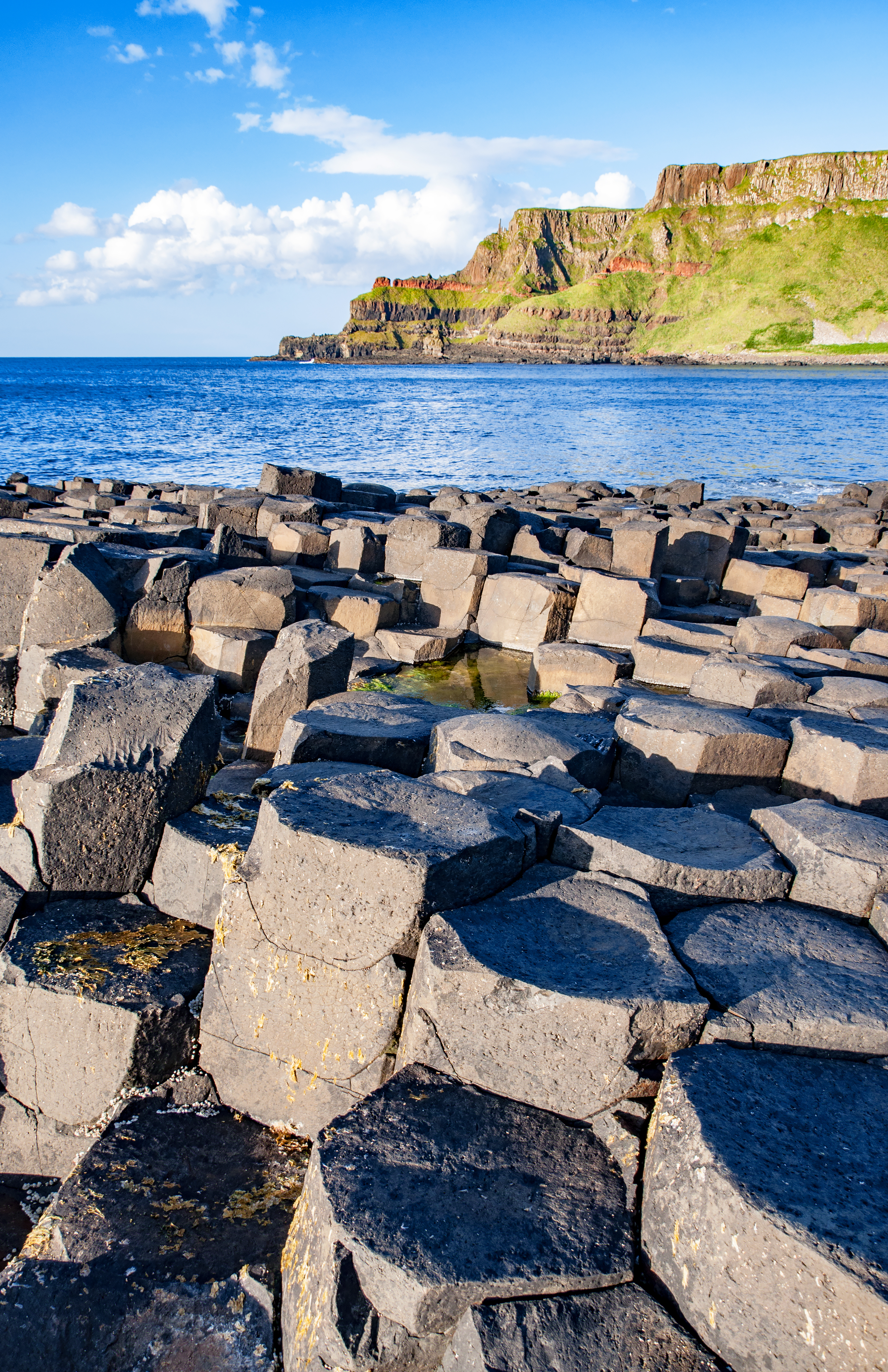Giants Causeway ved County Antrim i Nordirland med naturlige sekskantede basaltsøjler dannet af vulkansk aktivitet for millioner af år siden