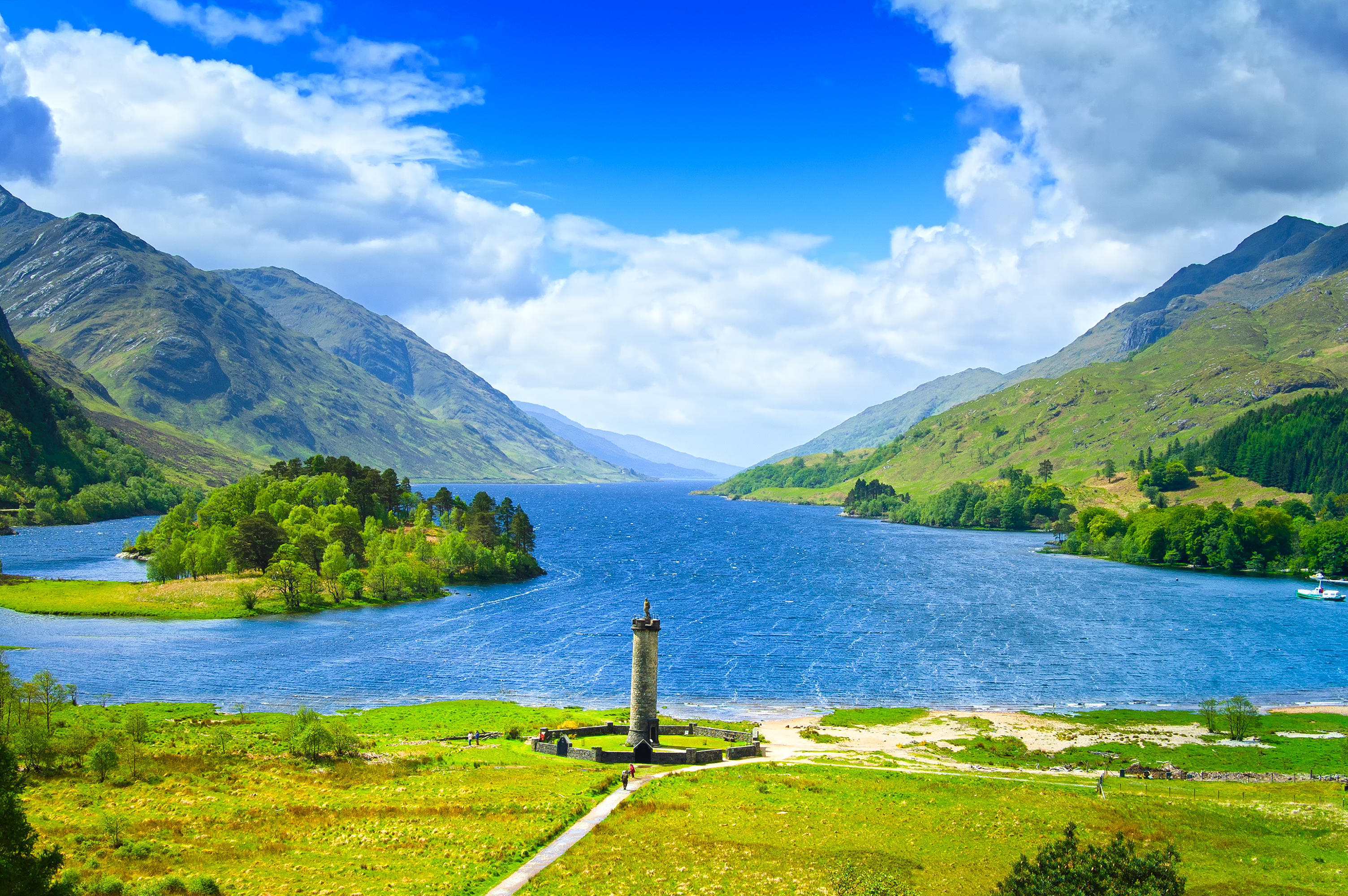 Det ikoniske Glenfinnan-monument med udsigt over den fredelige Loch Shiel sø omgivet af majestætiske bjerge i det skotske højland