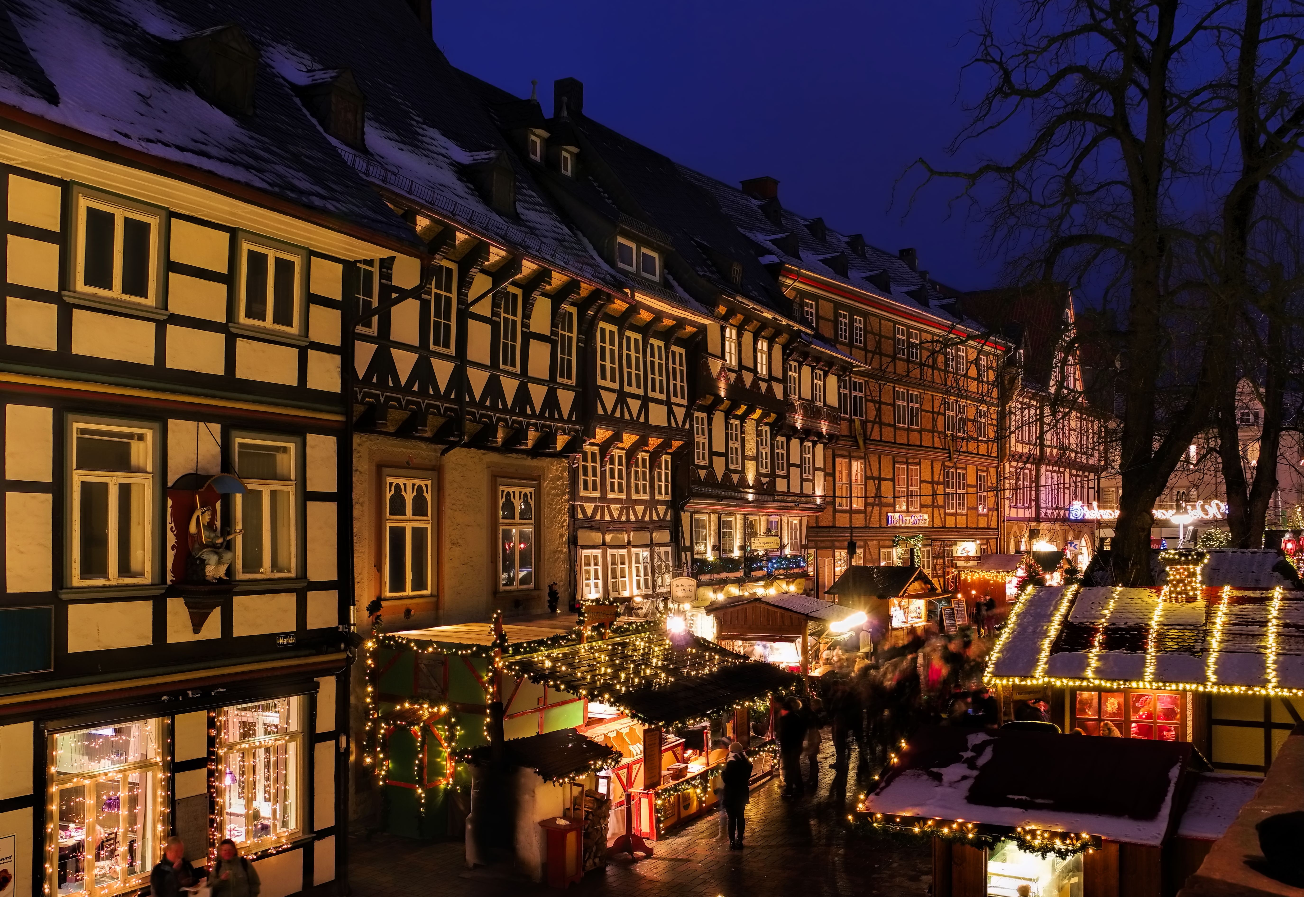 Adventsstemning ved Goslar julemarked med snedækkede tage og oplyste markedsstande langs historiske bindingsværkshuse