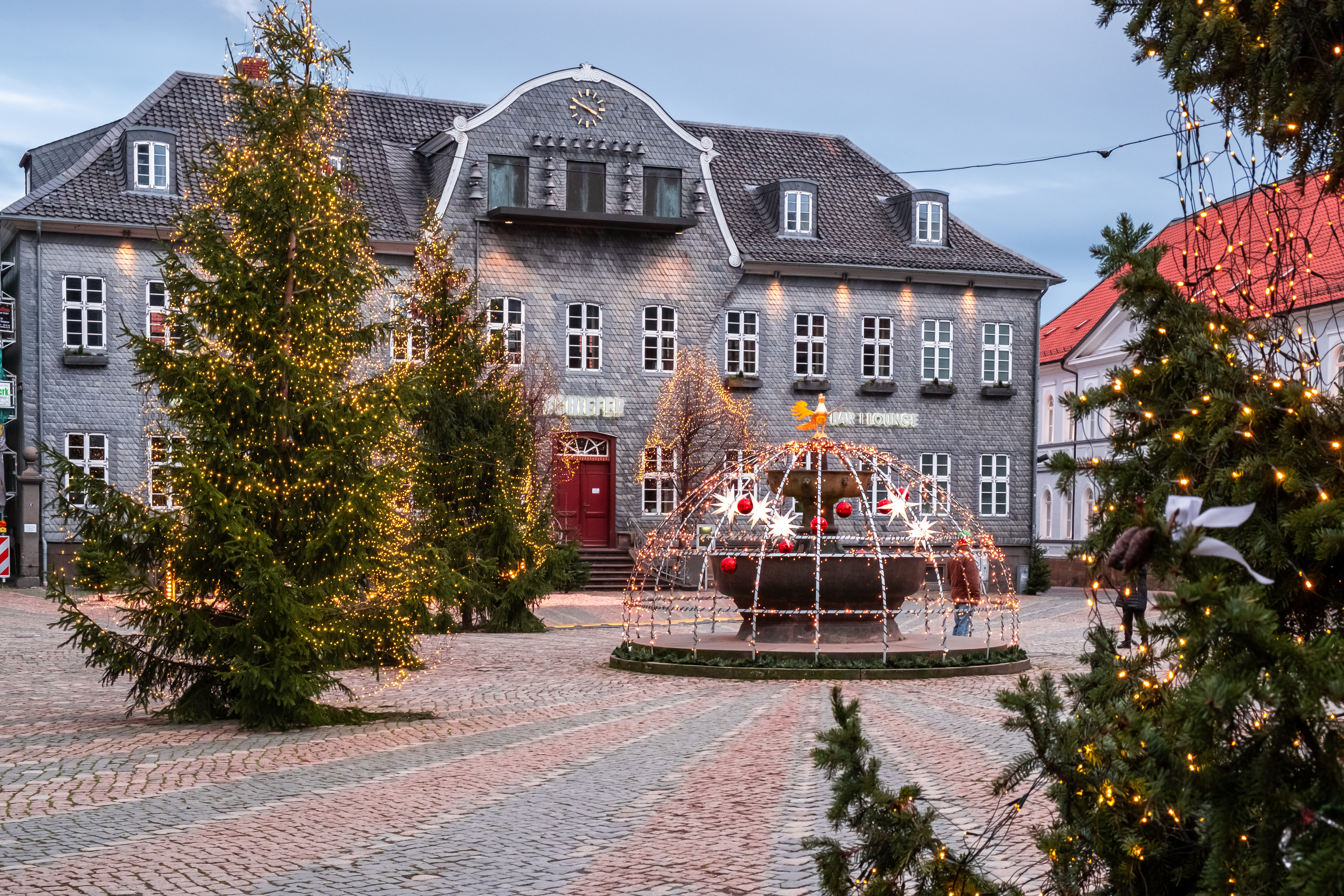 Julepyntet torv i Goslar med store juletræer og festlige lys foran historisk bygning i Niedersachsen, Tyskland