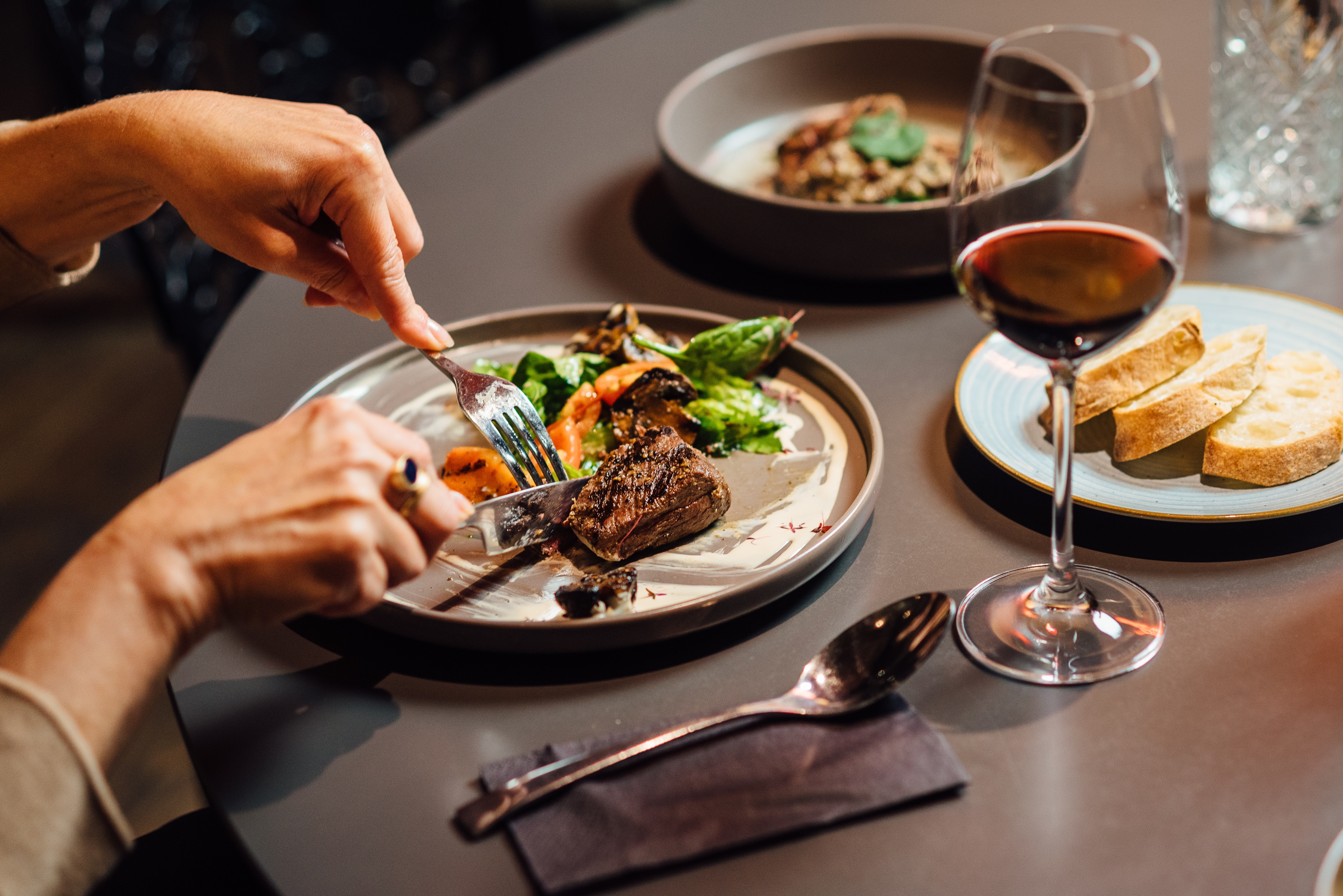 Gourmetmiddag med grillet strudsefilet, grillede grøntsager og rødvin på en moderne eksklusiv restaurant