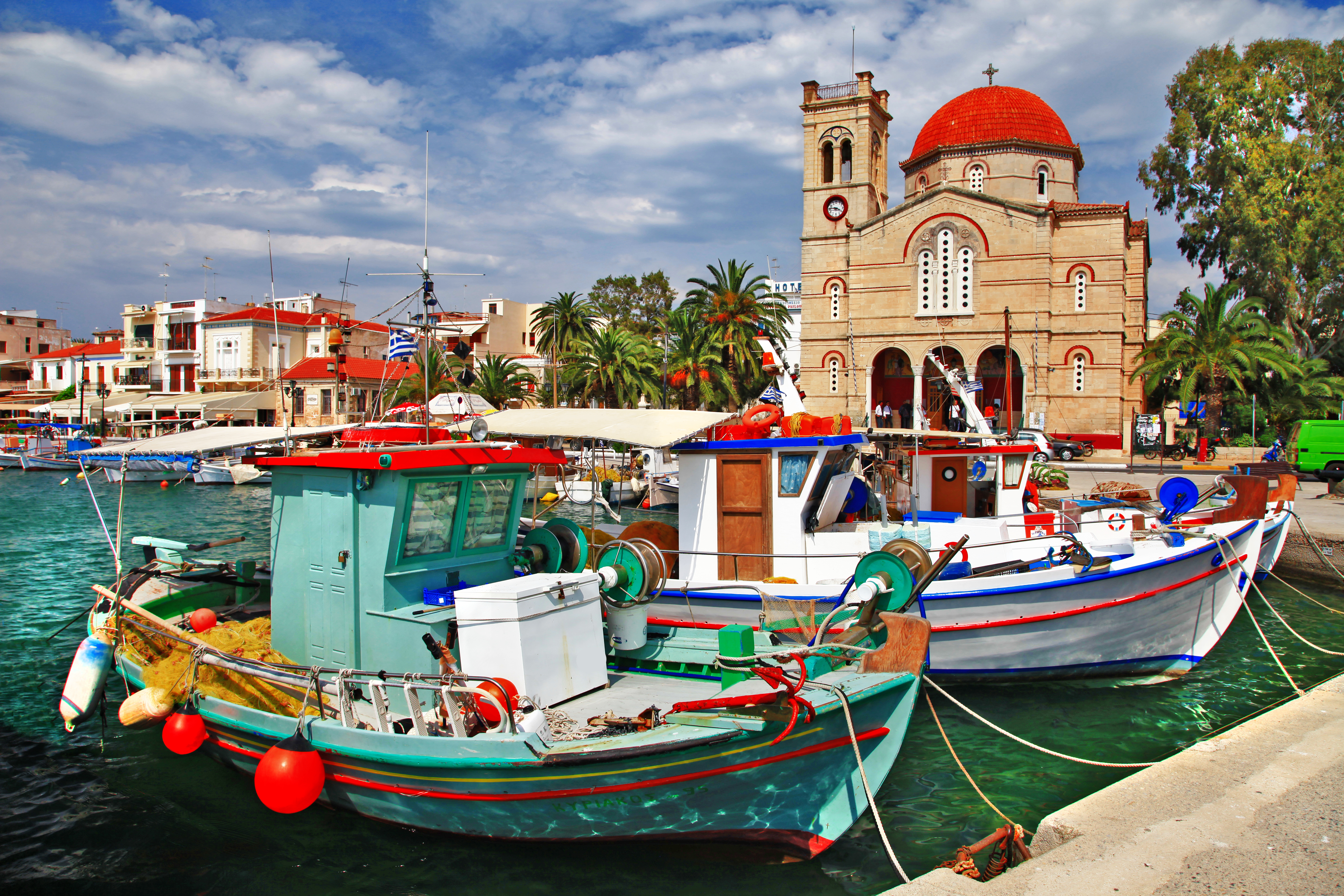 Traditionel græsk fiskerhavn på Aegina med pittoreske både og smuk kirke med rødt kuppeltag