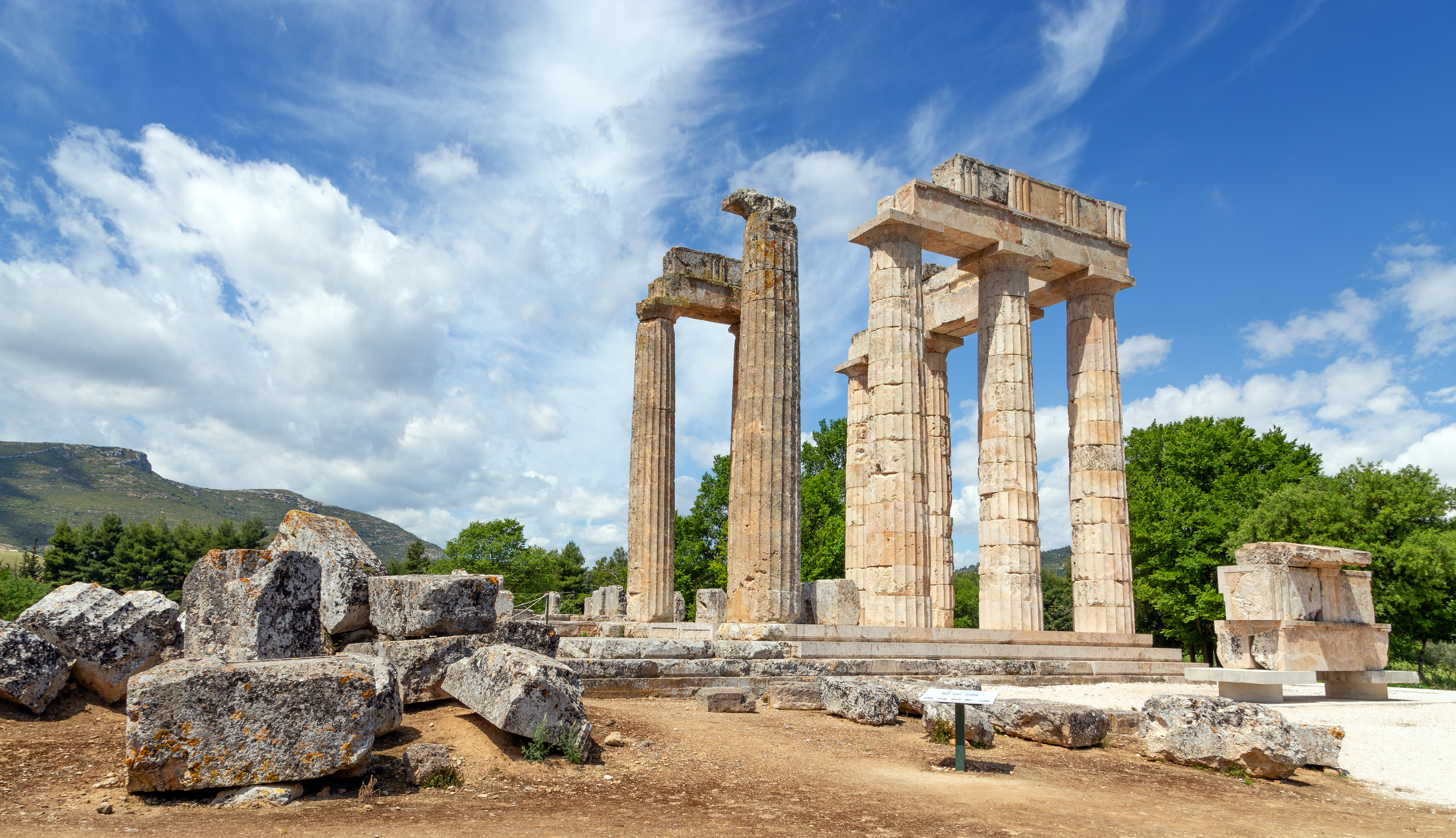 Majestætiske søjler fra det antikke Zeus-tempel i Nemea, Grækenland, omgivet af naturskøn natur på Peloponnes
