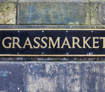 Elegant sort og guld gadeskilt til Grassmarket på historisk stenmur i Edinburgh, Skotland
