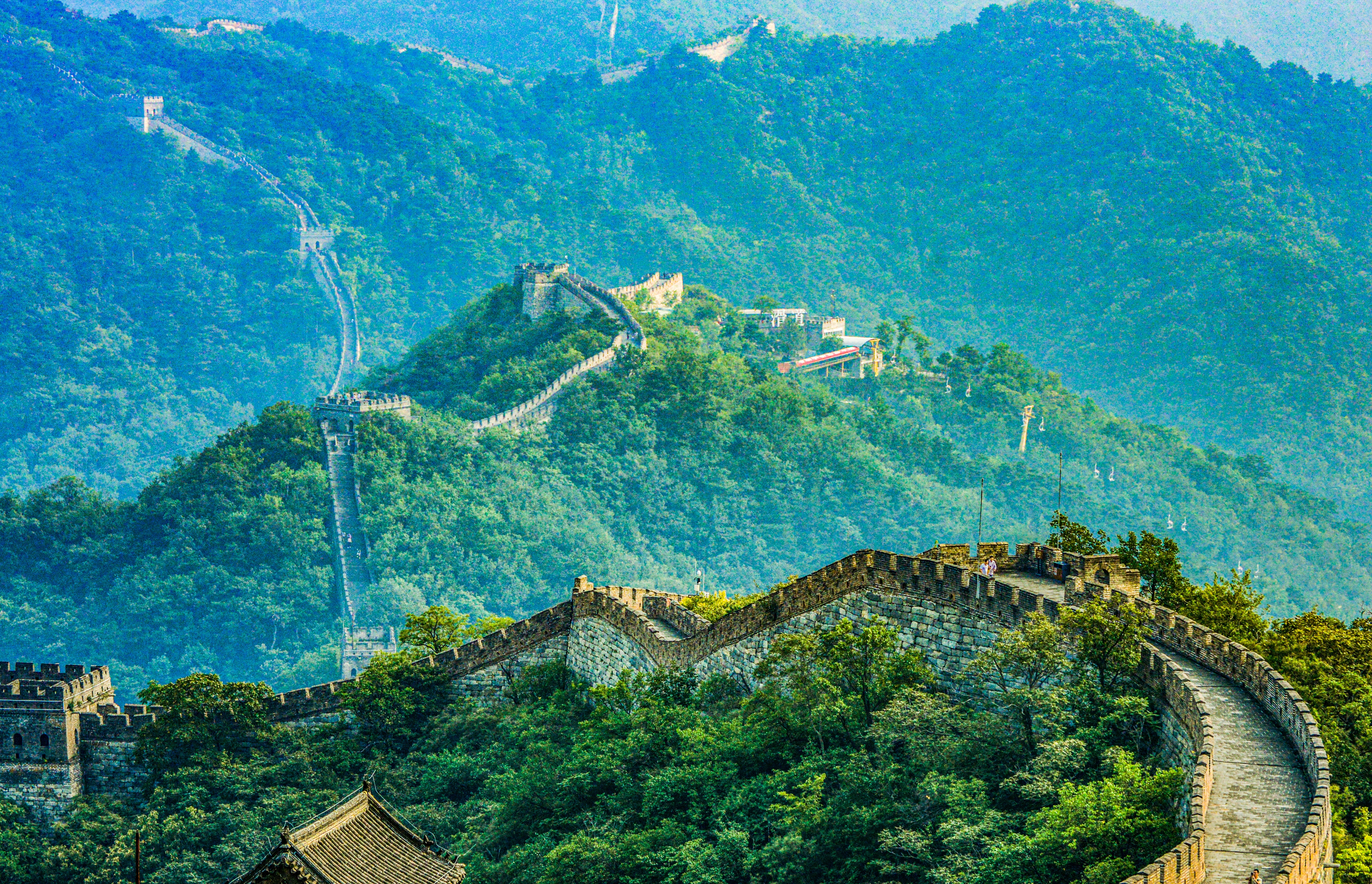 Panoramaudsigt over Den Kinesiske Mur der strækker sig over grønne bjerge ved Beijing