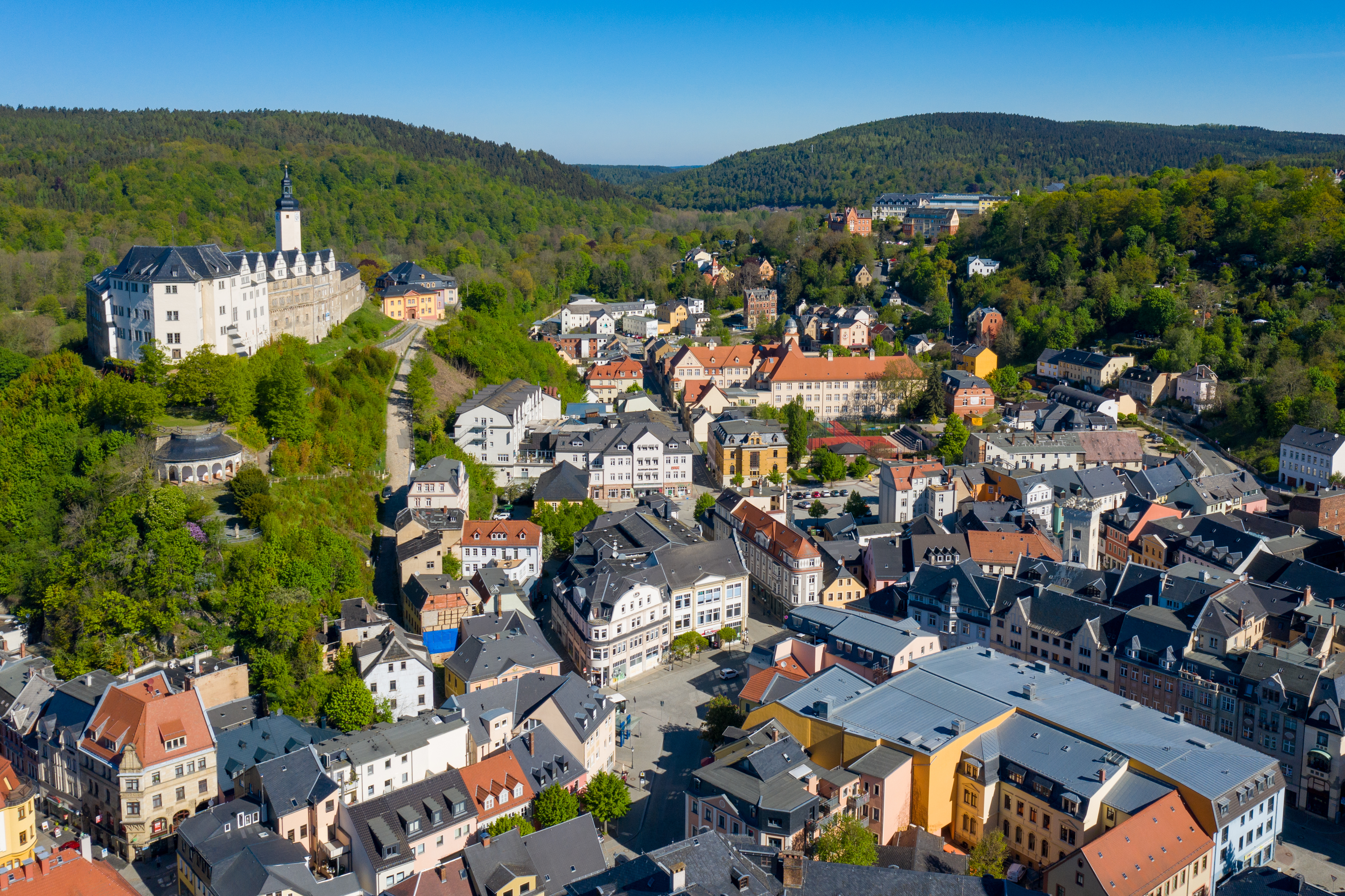 Fugleflugtsperspektiv over Greiz i Thüringen med det majestætiske slot og den historiske bymidte omringet af frodige grønne bakker