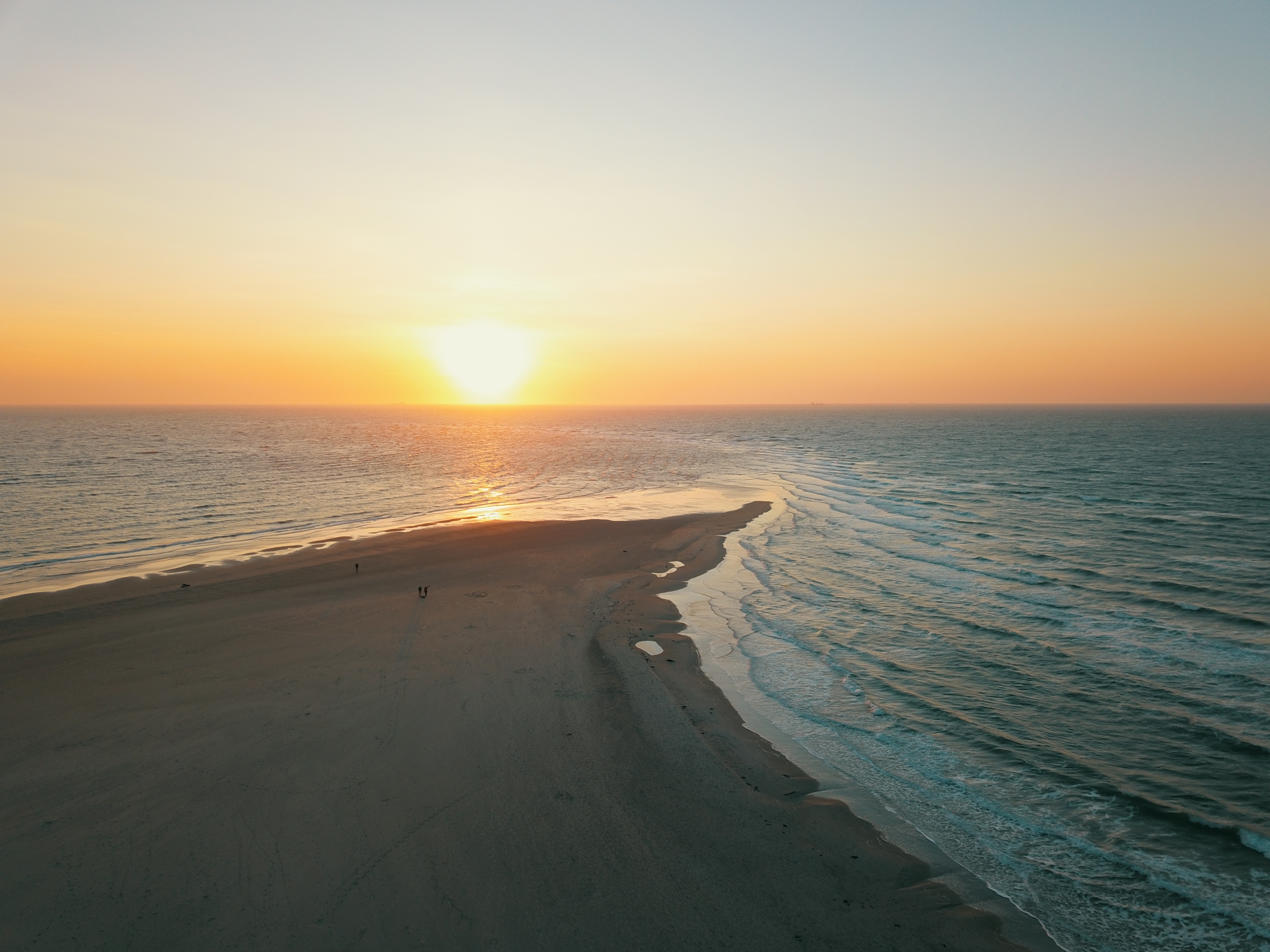 Luftfoto fra Grenen i Skagen Danmark ved solnedgang med to have der mødes ved sandstranden