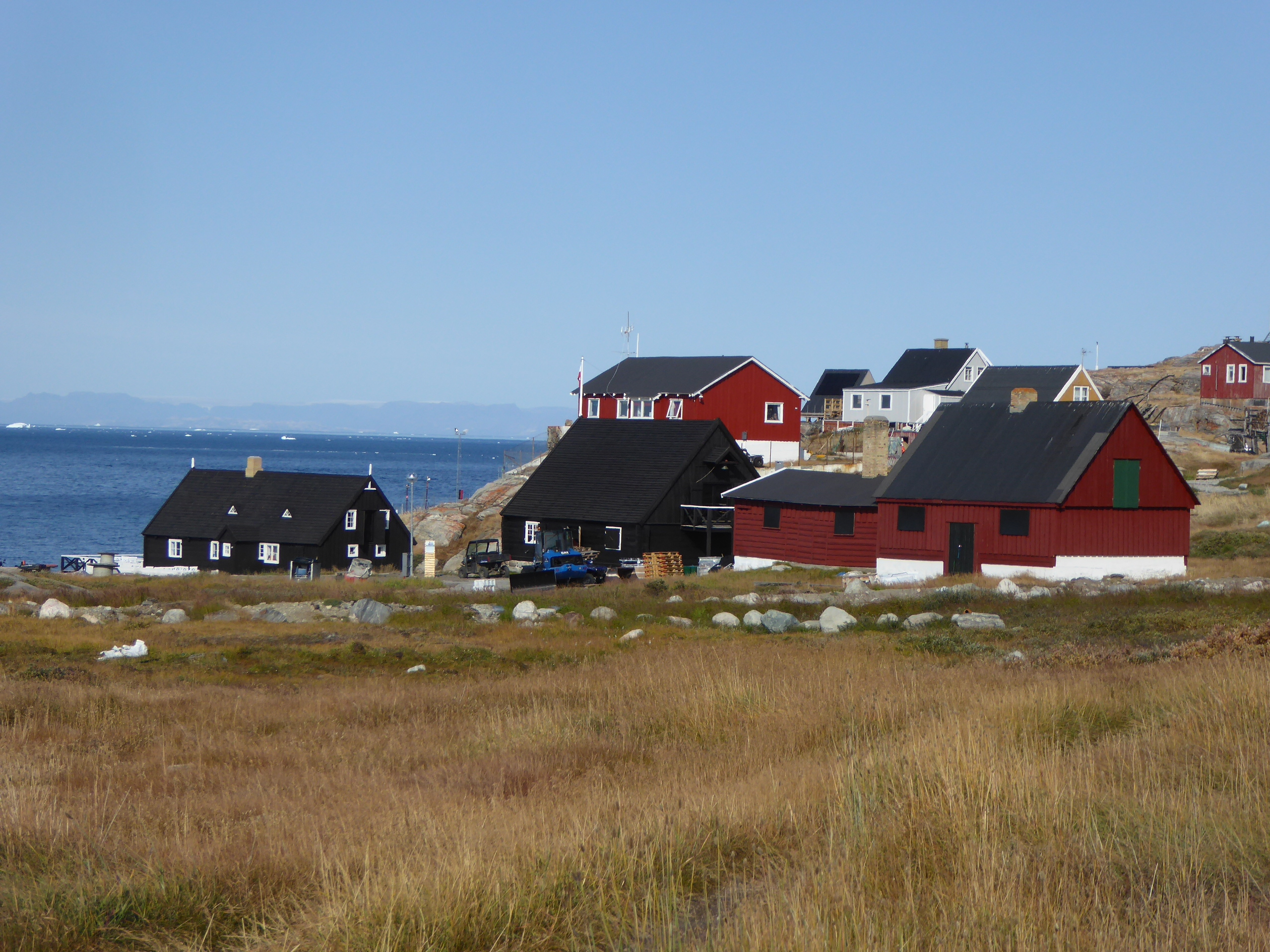 Charmerende kystlandsby omgivet af arktisk tundra i Grønland