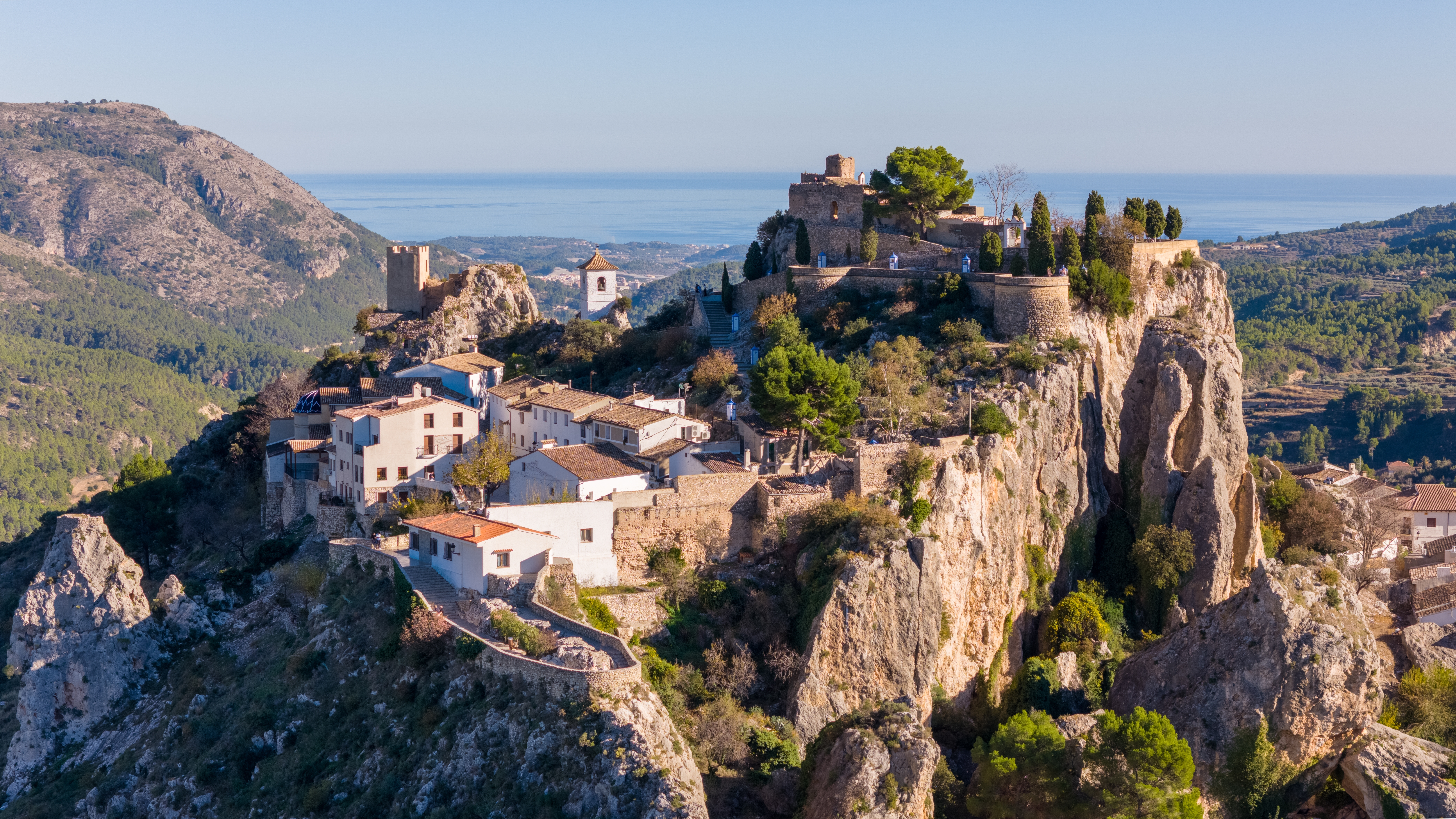 Fascinerende fugleperspektiv af Guadalest med historisk slot og charmerende bjerglandsby omgivet af reservoirsø i Costa Blanca