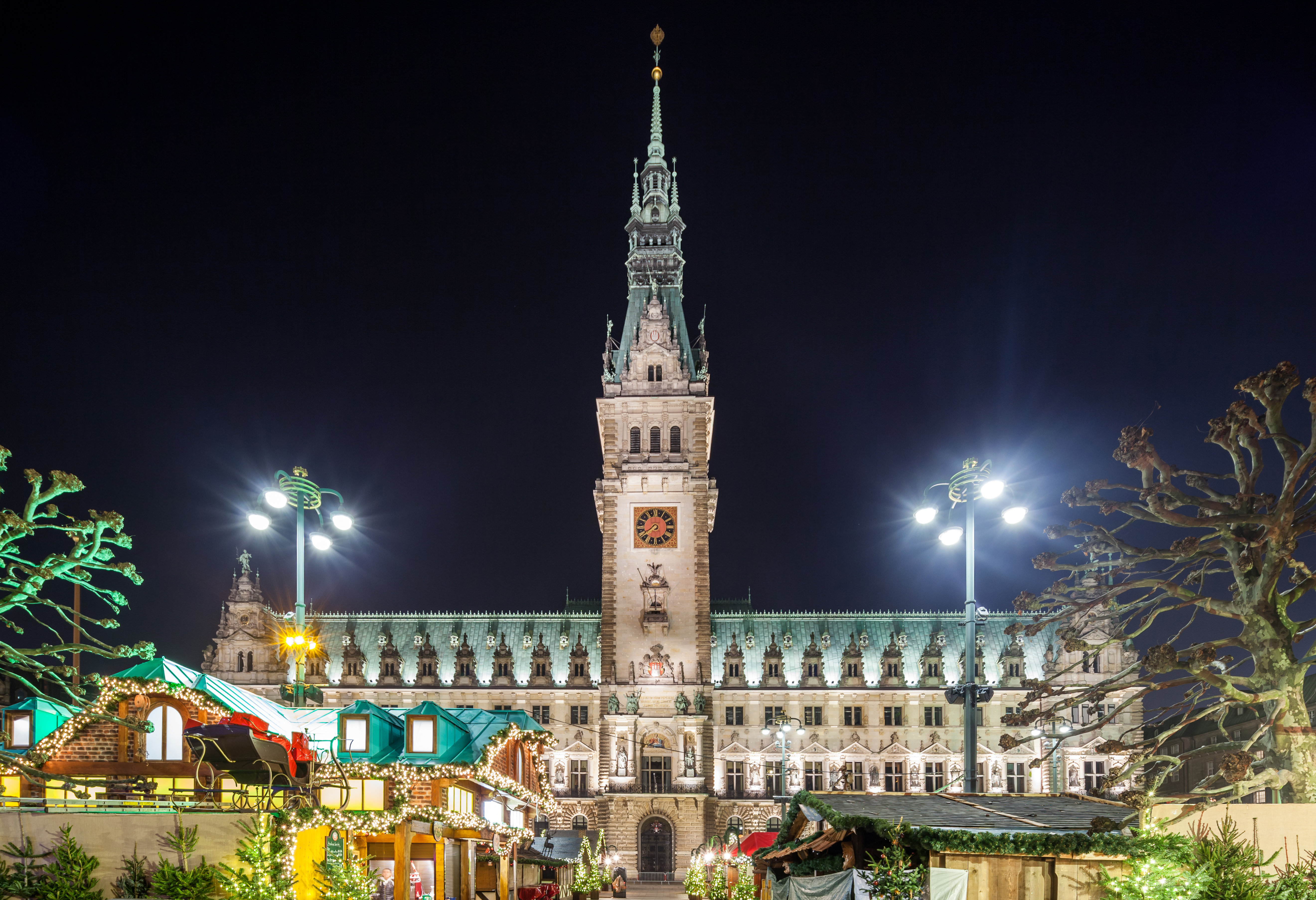 Hamburg rådhus og julemarked smukt oplyst i mørket med festlig stemning