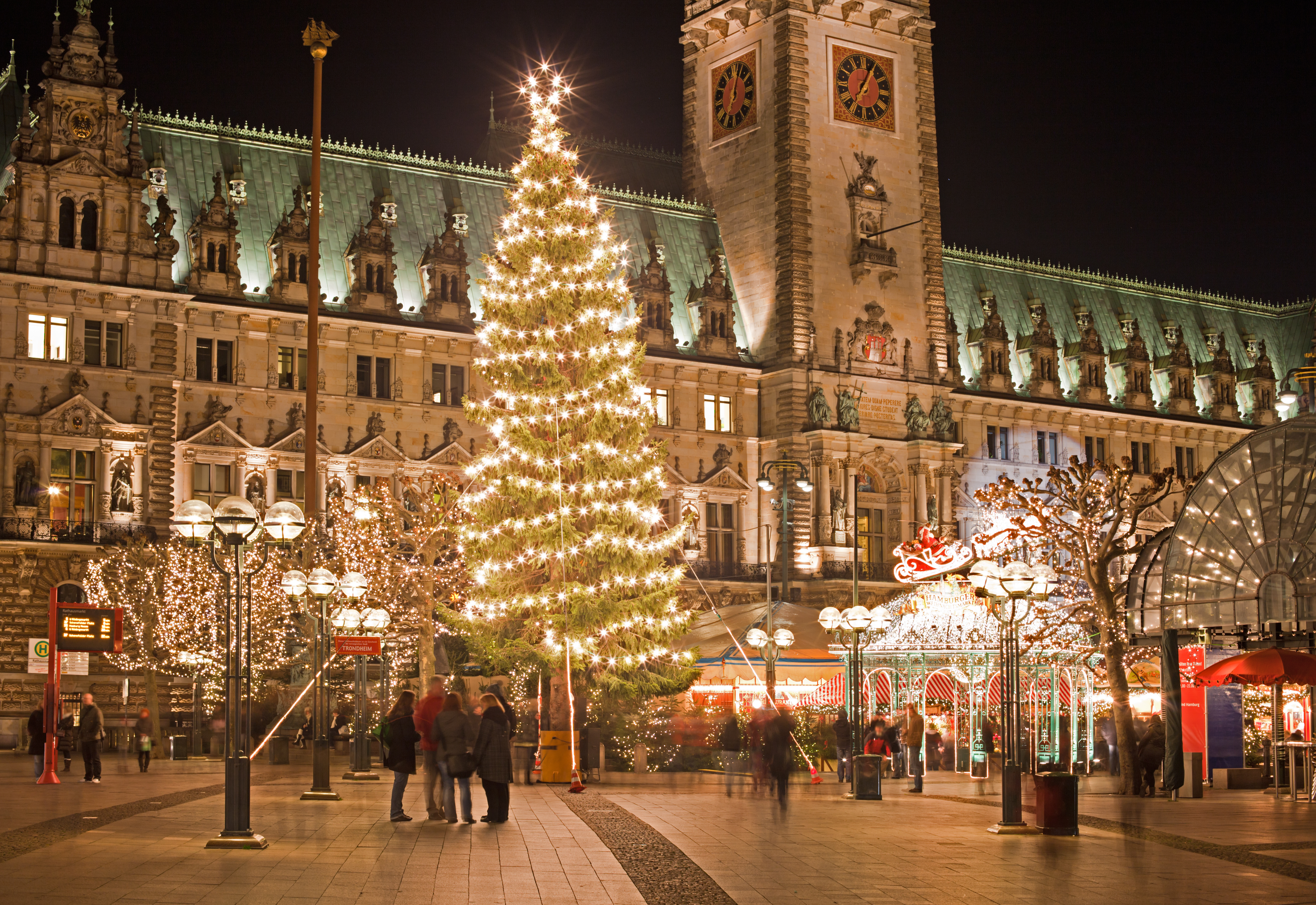 Klassisk tysk julemarked i Hamburg ved Rathausmarkt med smukt oplyst juletræ og historisk rådhus