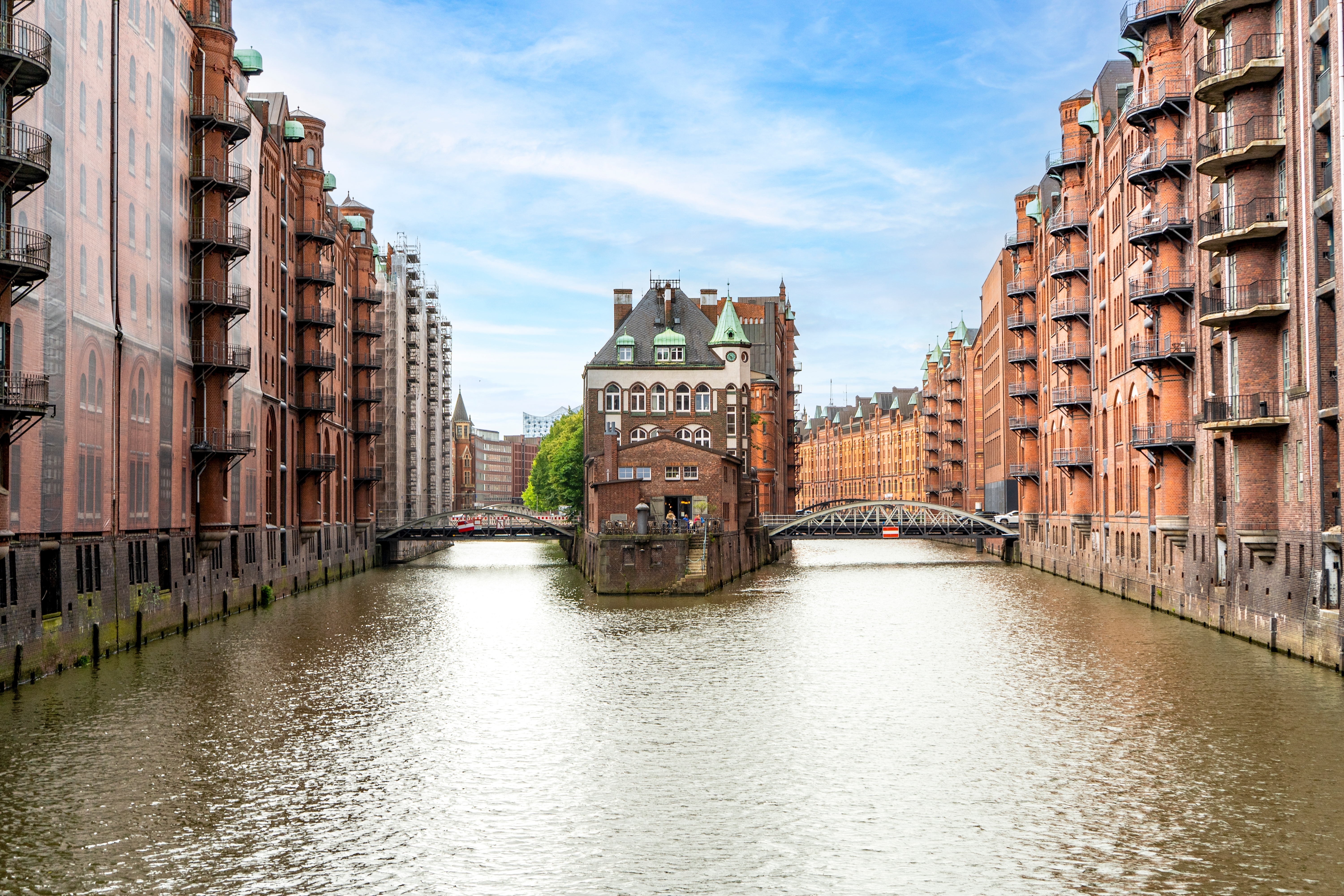 Ikonisk udsigt over Speicherstadt i Hamburg med historiske røde teglstensbygninger langs vandkanalen og Wasserschloss