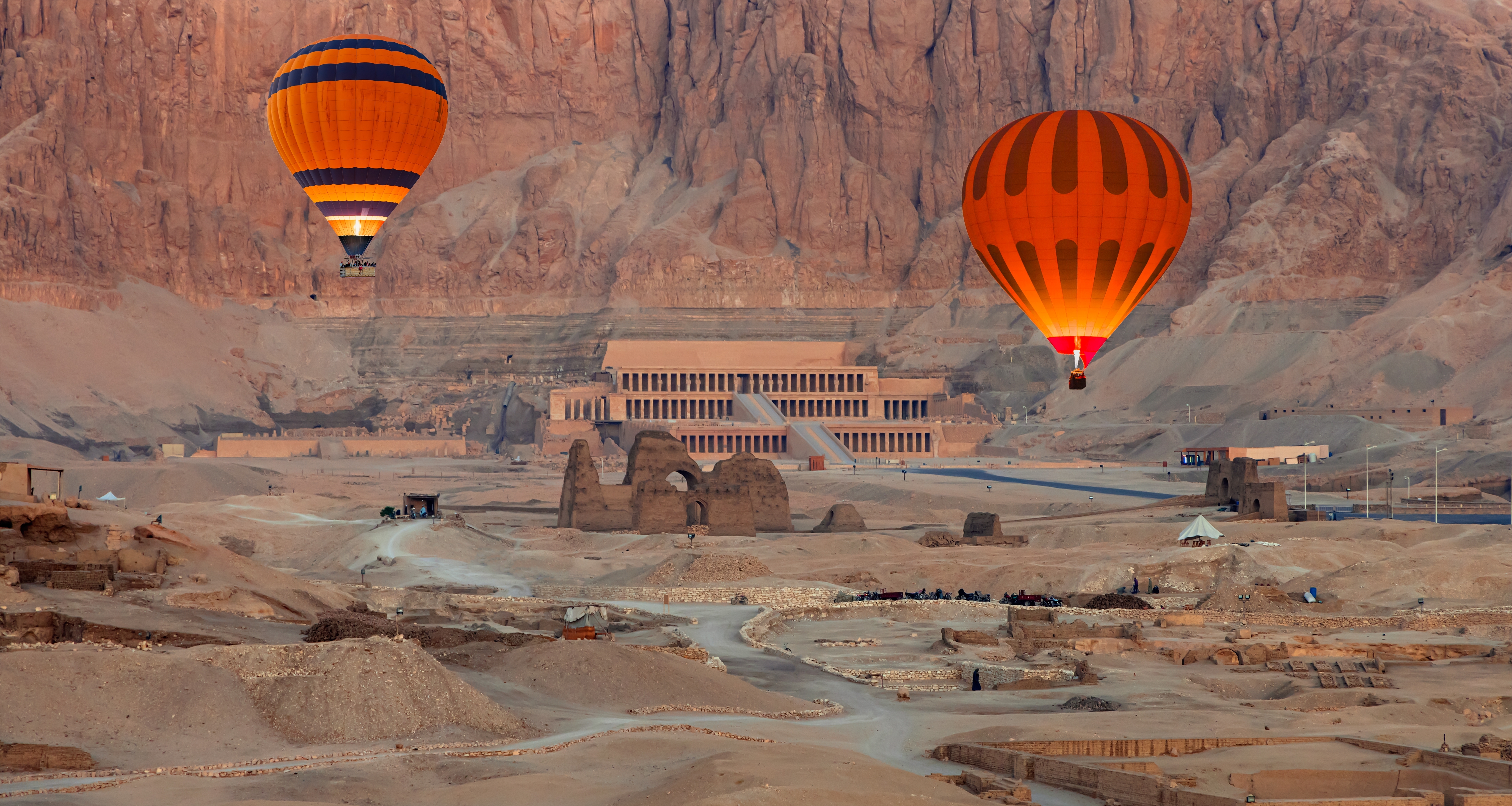 Orange luftballoner svæver over det majestætiske Hatshepsut-tempel i ørkenen ved Luxor