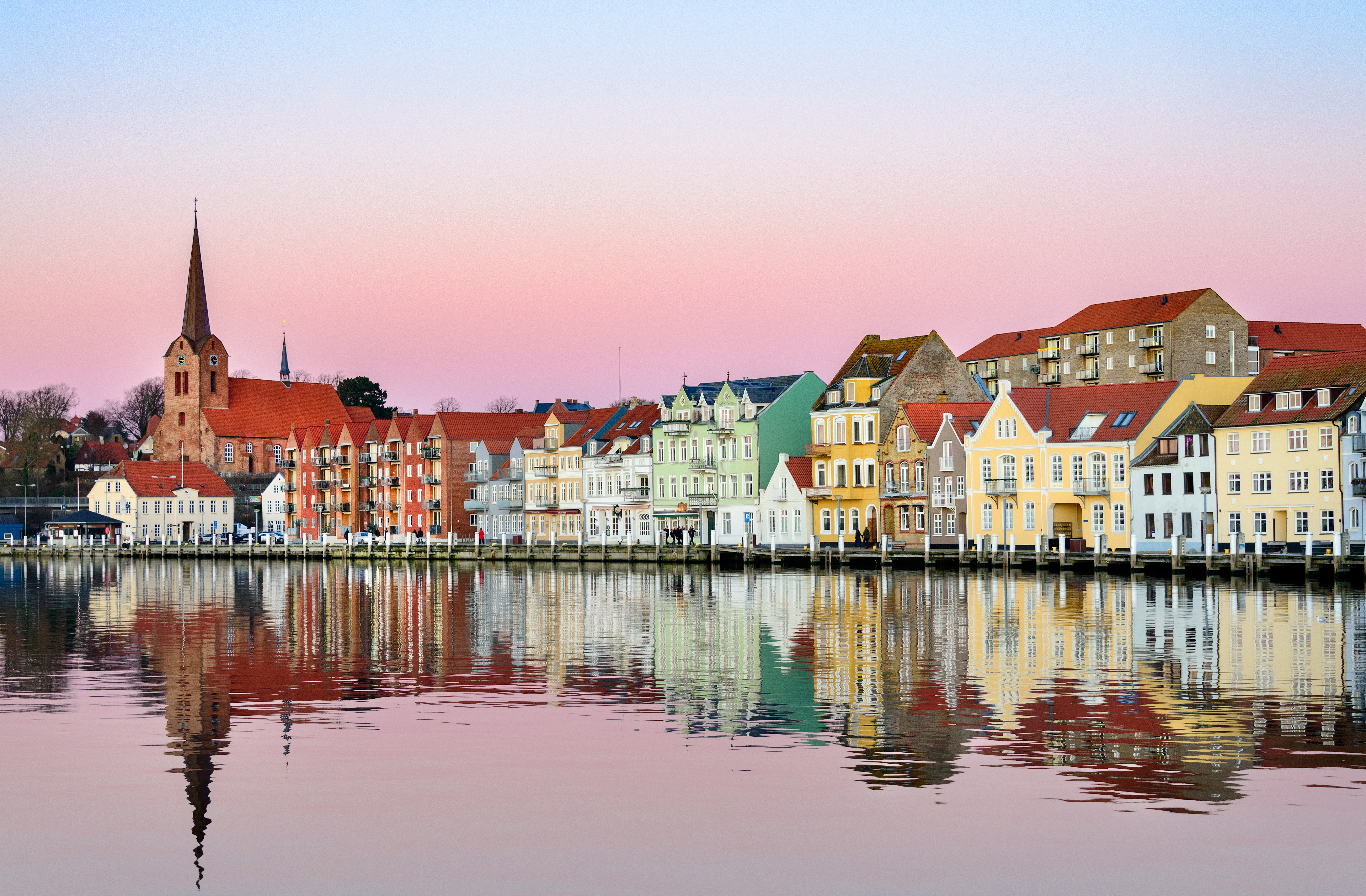 Charmerende havnefront med klassiske nordiske huse og smuk vandspejling