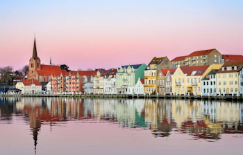 Charmerende havnefront med klassiske nordiske huse og smuk vandspejling