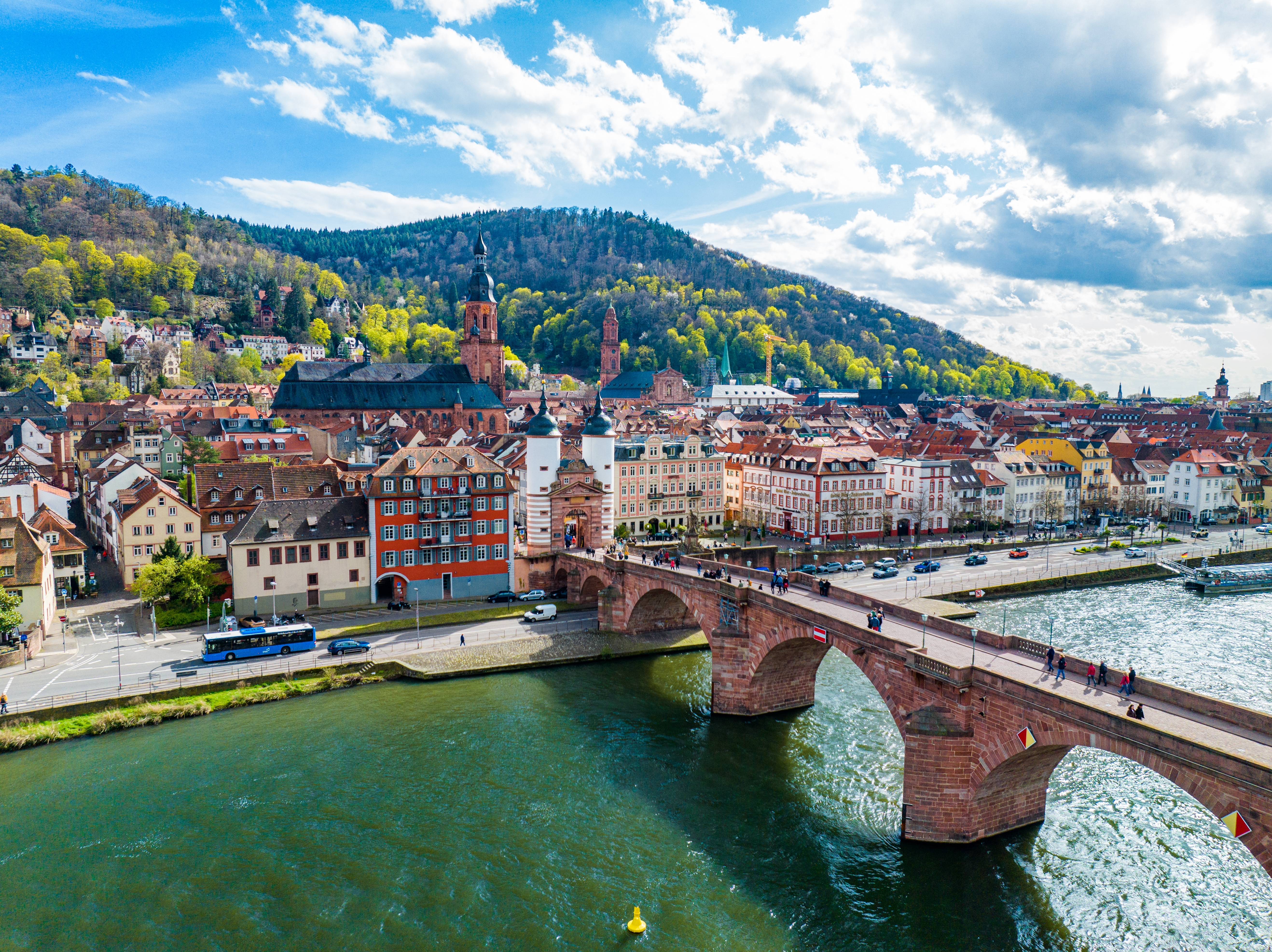 Forårspanorama over Heidelbergs gamle bydel med middelalderlig bro over Neckar-floden og skovklædte bakker i baggrunden, Tyskland