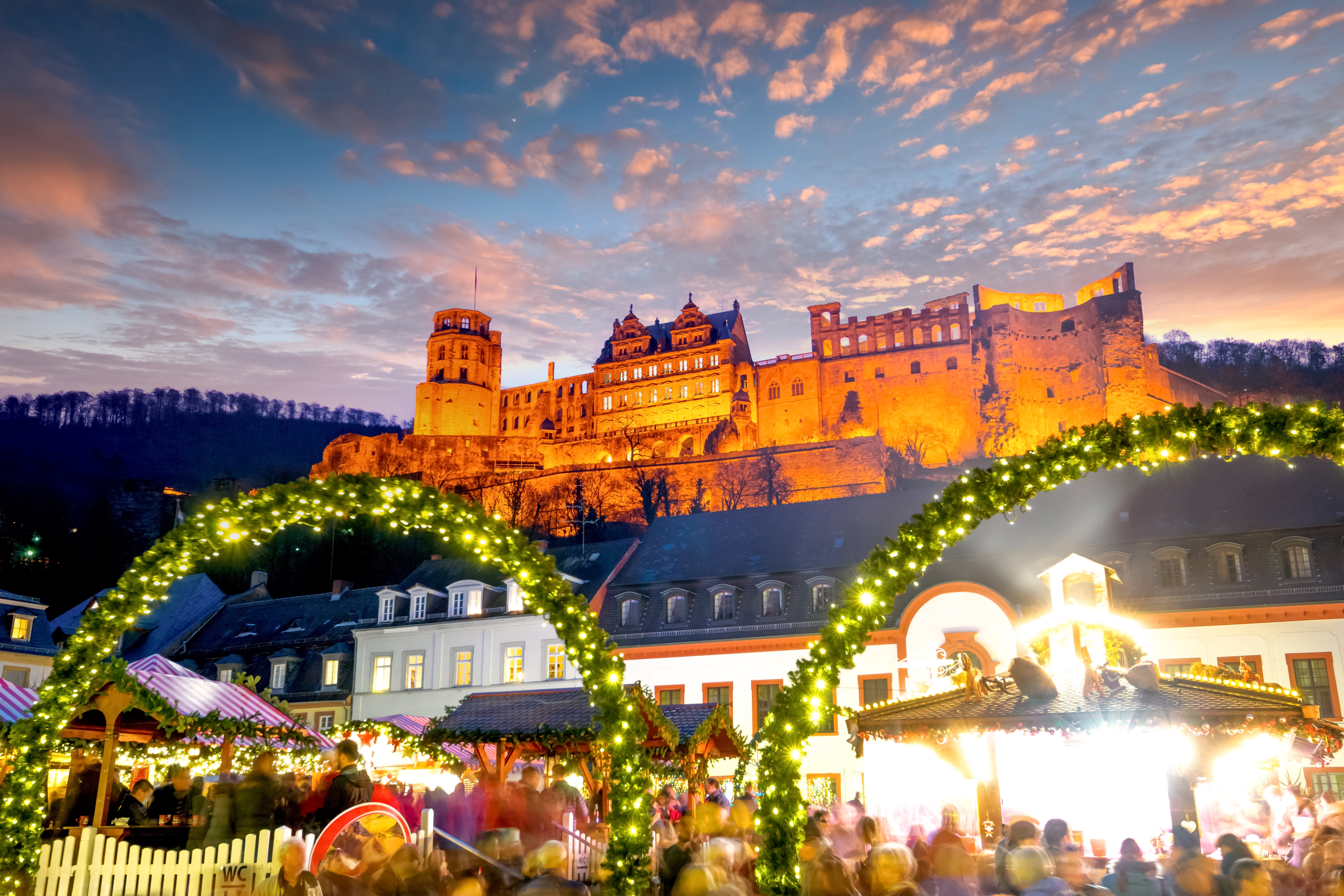 Magisk julemarked i Heidelberg med lysdekorationer og det imponerende Heidelberg Slot oplyst i aftenmørket, Baden-Württemberg, Tyskland
