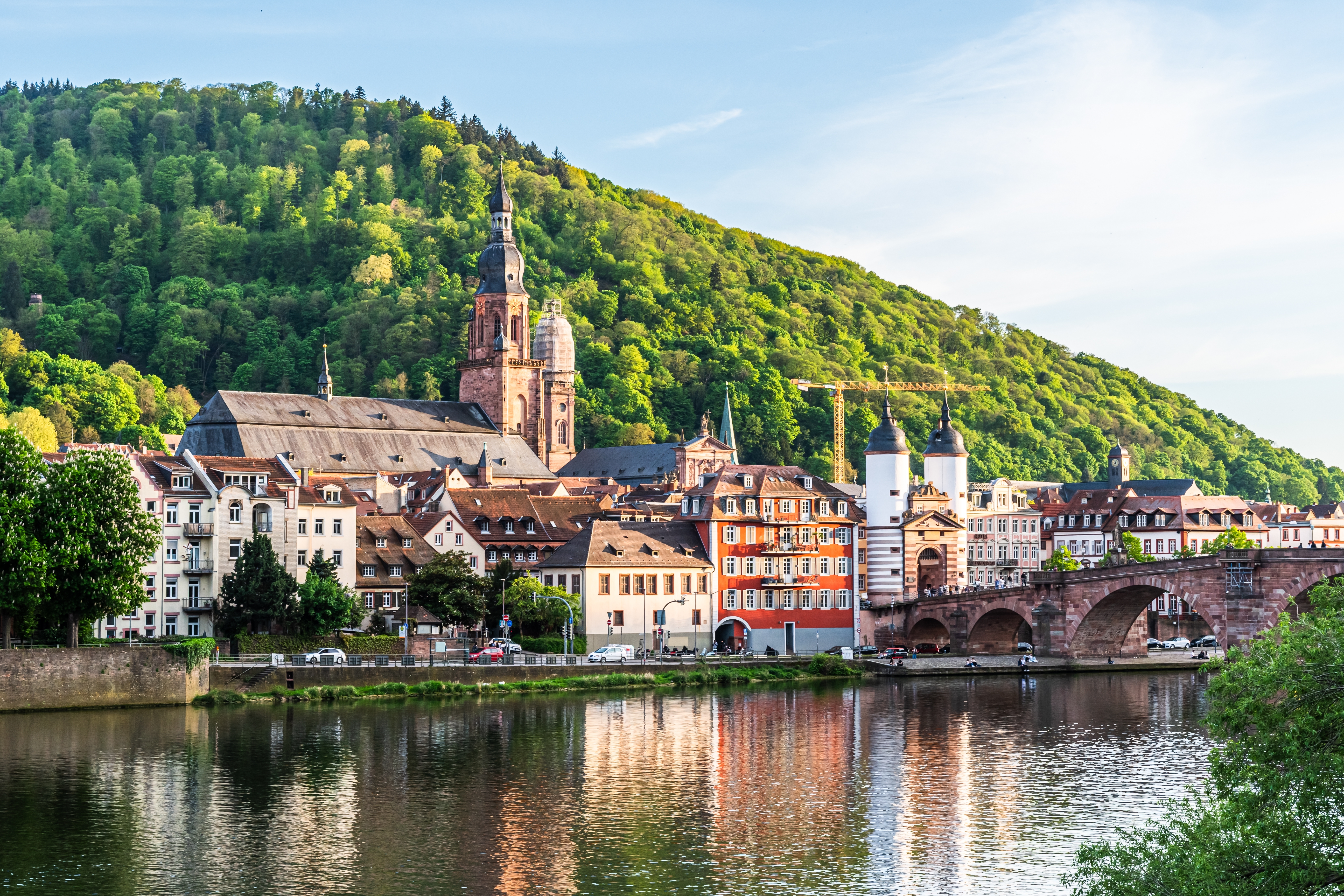 Malerisk udsigt over Heidelbergs gamle by med historisk bro, kirketårne og traditionelle tyske huse ved Neckar-floden