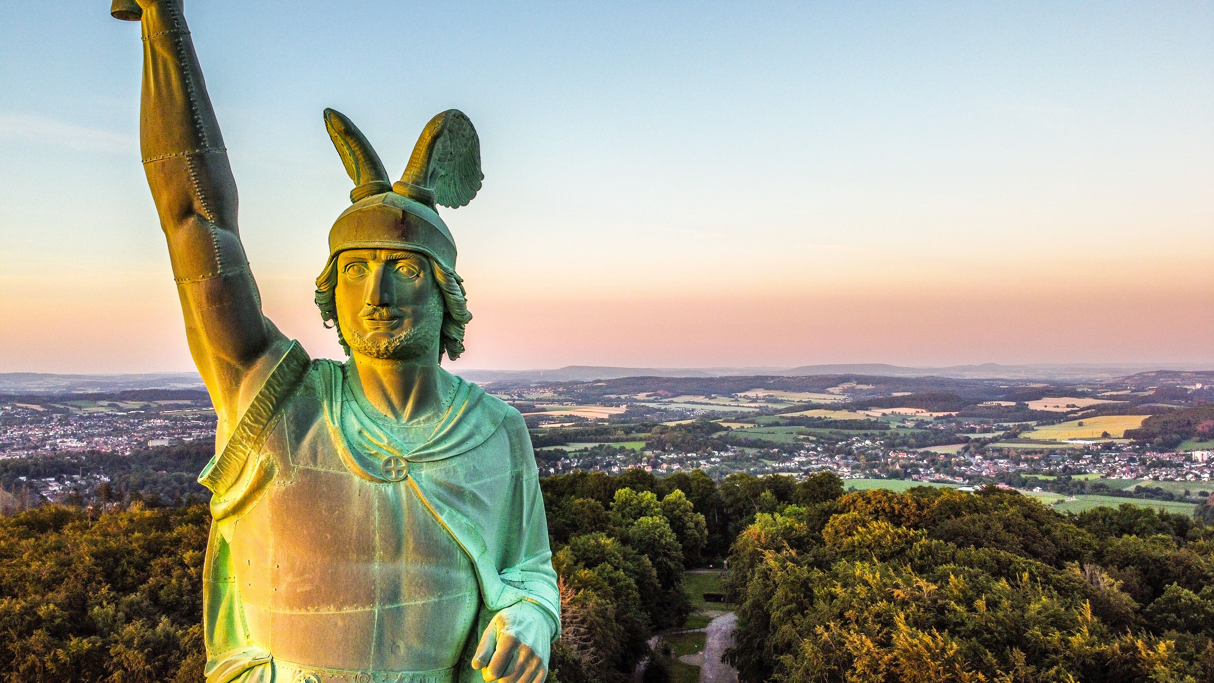 Det majestætiske Hermann-monument i Teutoburg-skoven ved Detmold, Tyskland, fotograferet ved solnedgang med vid udsigt over det grønne landskab