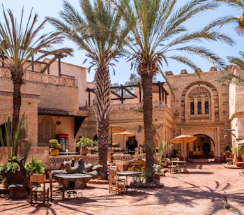 Pittoresk marokkansk borggård med dadelpalmer og traditionel berber arkitektur i Agadir