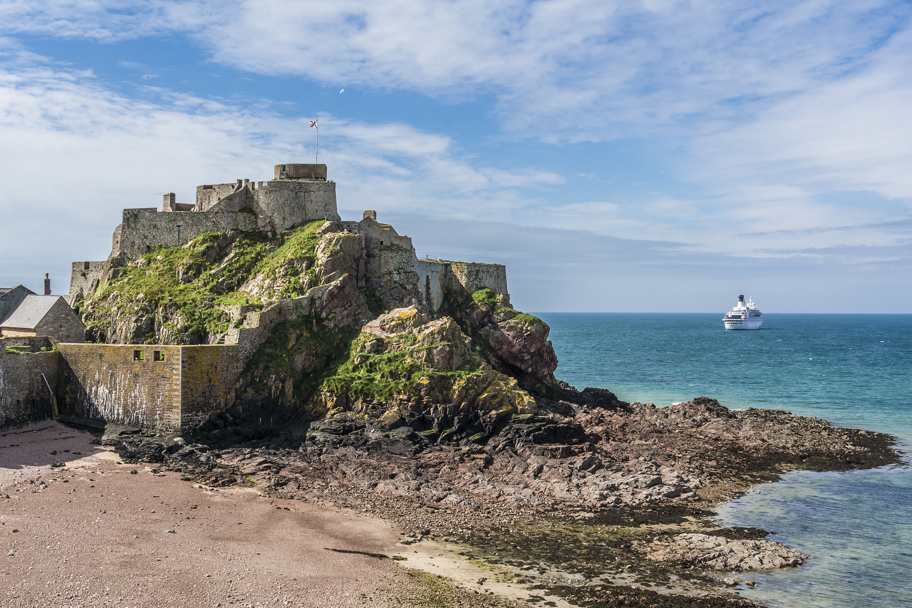 Historisk slot på Jersey Channel Islands med strand og turkisblåt hav