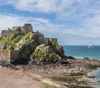 Historisk slot på Jersey Channel Islands med strand og turkisblåt hav