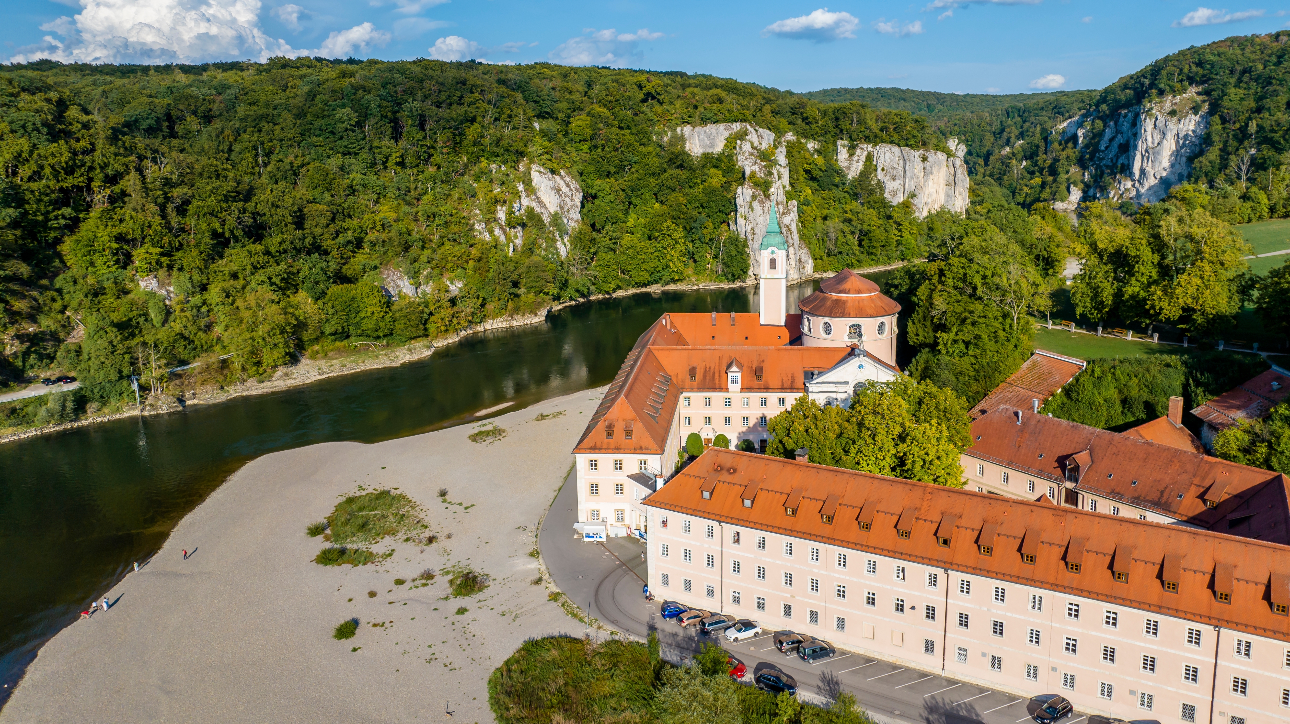Historisk kloster med kirketårn ved Donau-floden set fra luften i det sydlige Tyskland