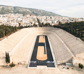 Historisk Panathenaic Stadion i Athen med hvide marmorsæder og byudsigt