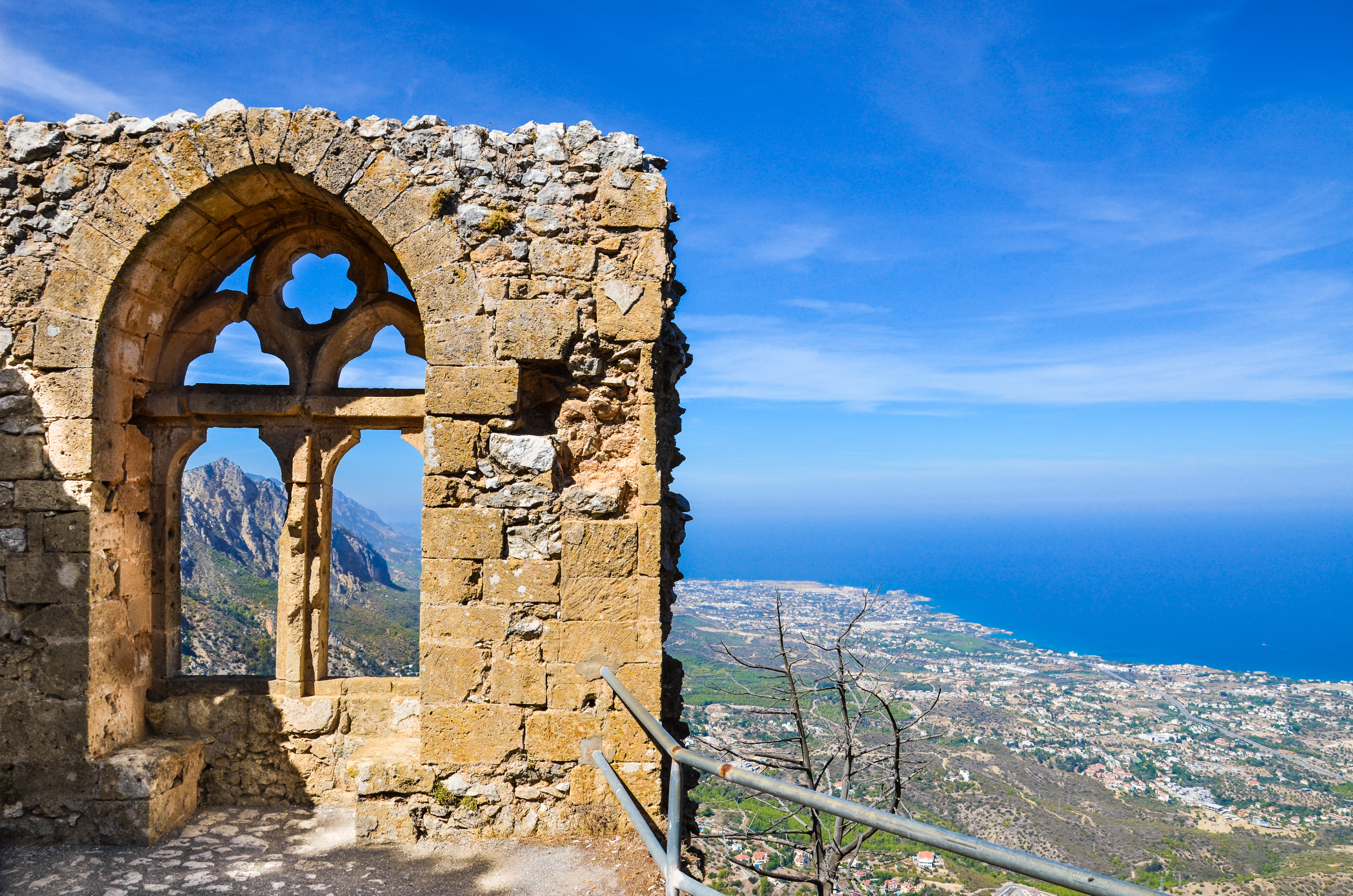Malerisk udsigt gennem et ældgammelt stenvindue i St. Hilarion-borgen med panorama over Kyrenia-kysten og det blå Middelhav på Cypern