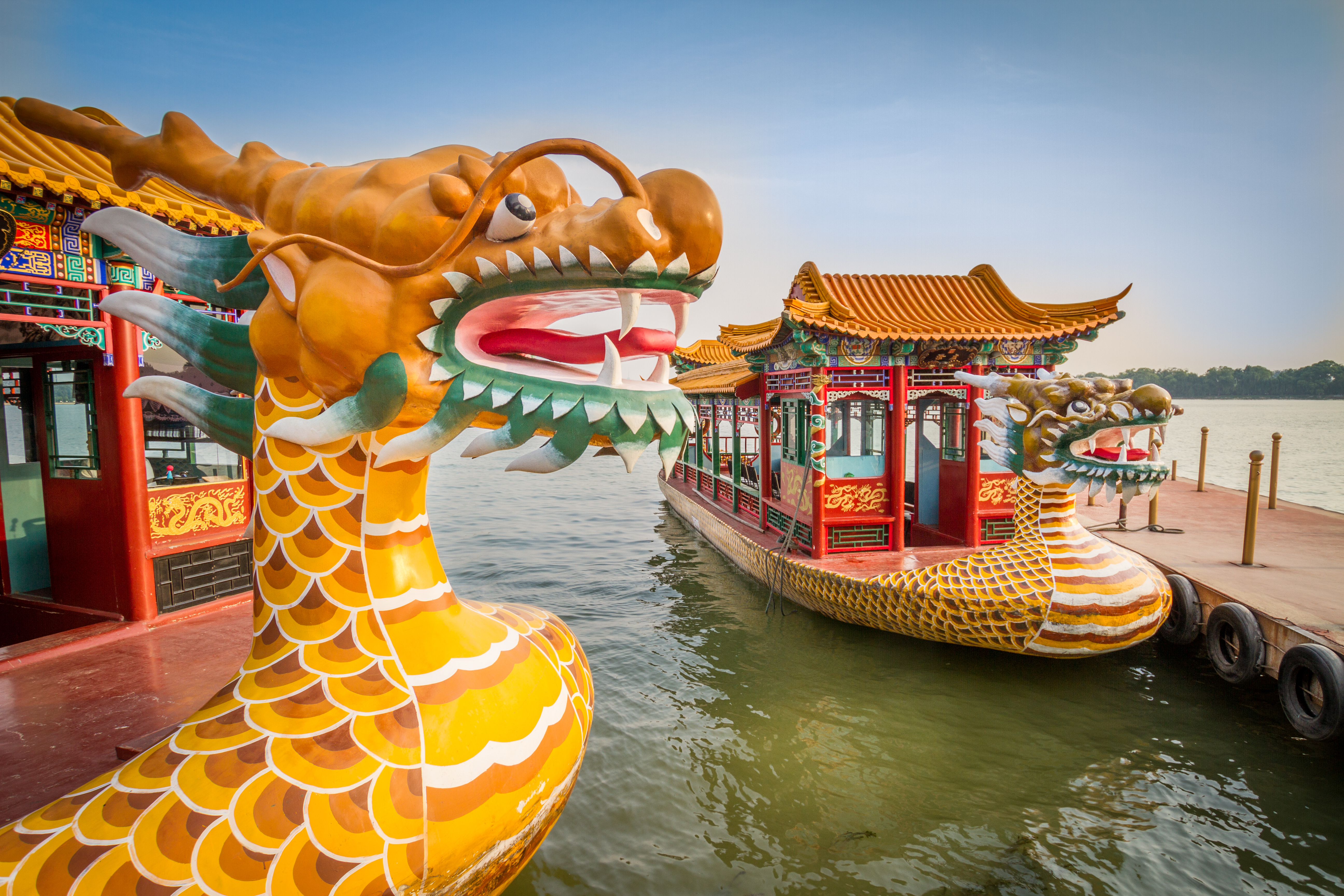 Ikoniske kinesiske dragebaade med detaljerig udsmykning og dragehoved ved Sommerpaladset i Beijing, symbol paa Kinas rige kulturarv