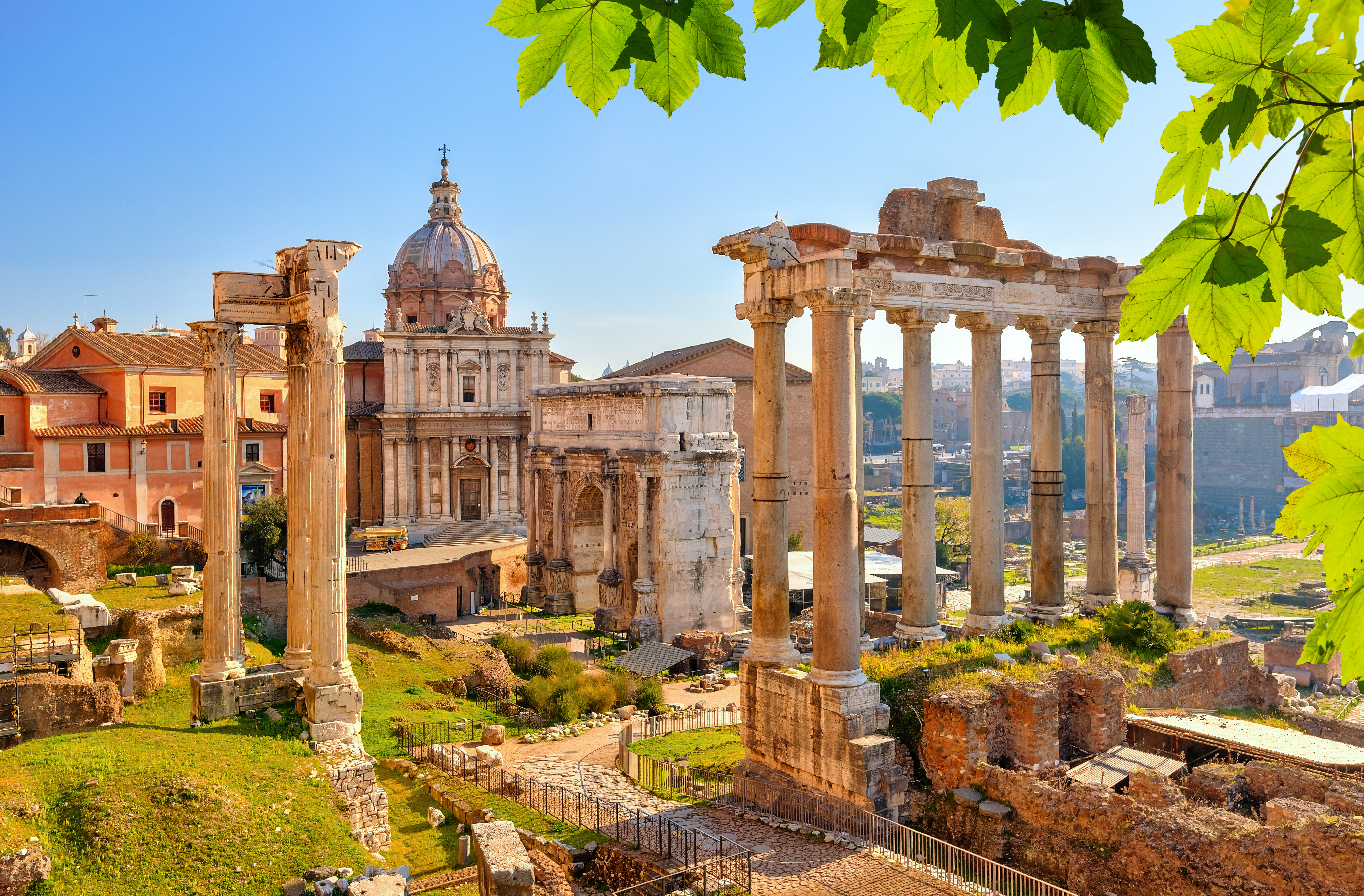 Antikke søjler og ruiner i Forum Romanum med udsigt til den berømte Septimius Severus-bue og Saturns tempel i hjertet af Rom
