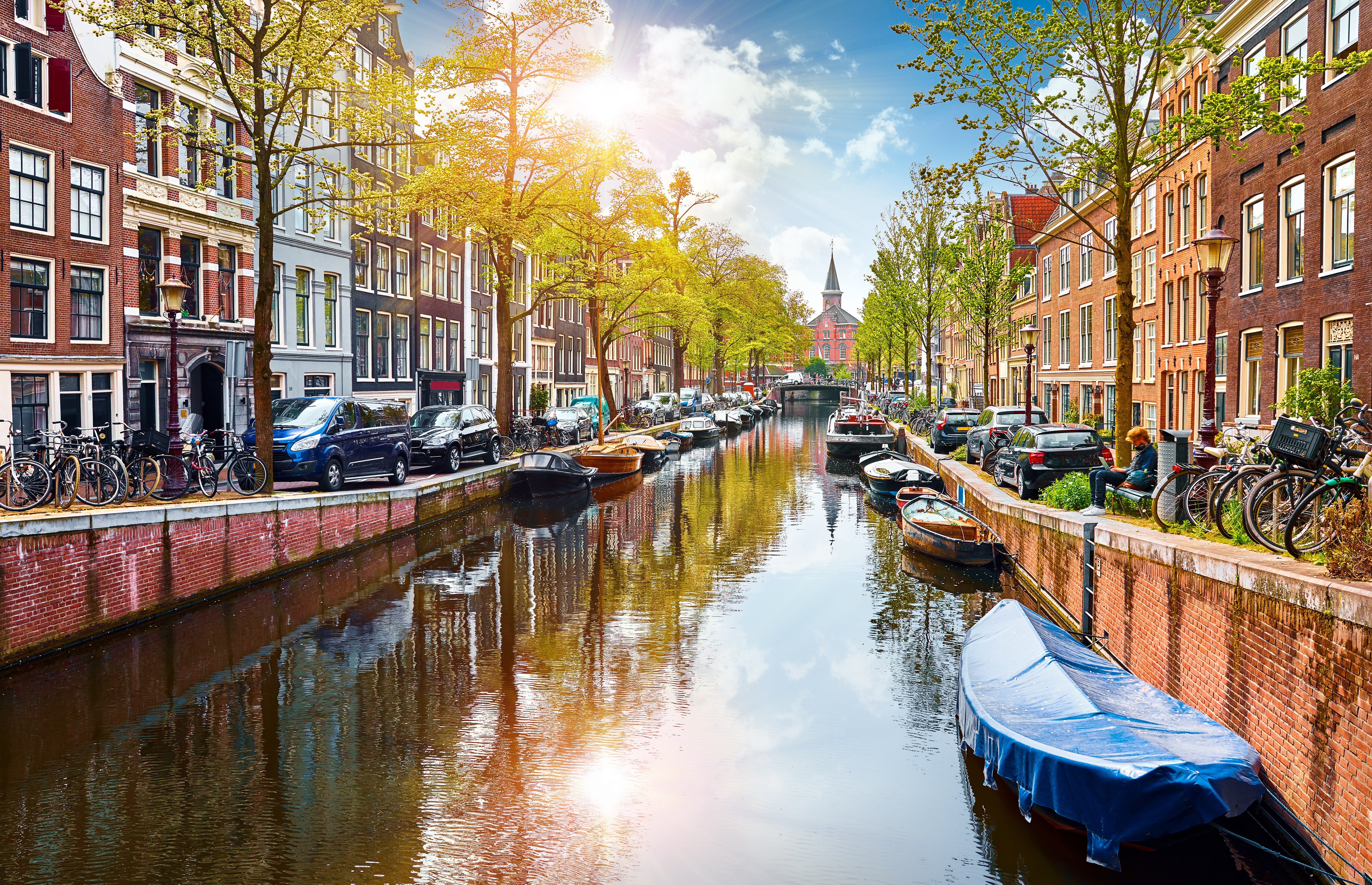 Idyllisk Amsterdam kanal med både, cykler og karakteristiske huse
