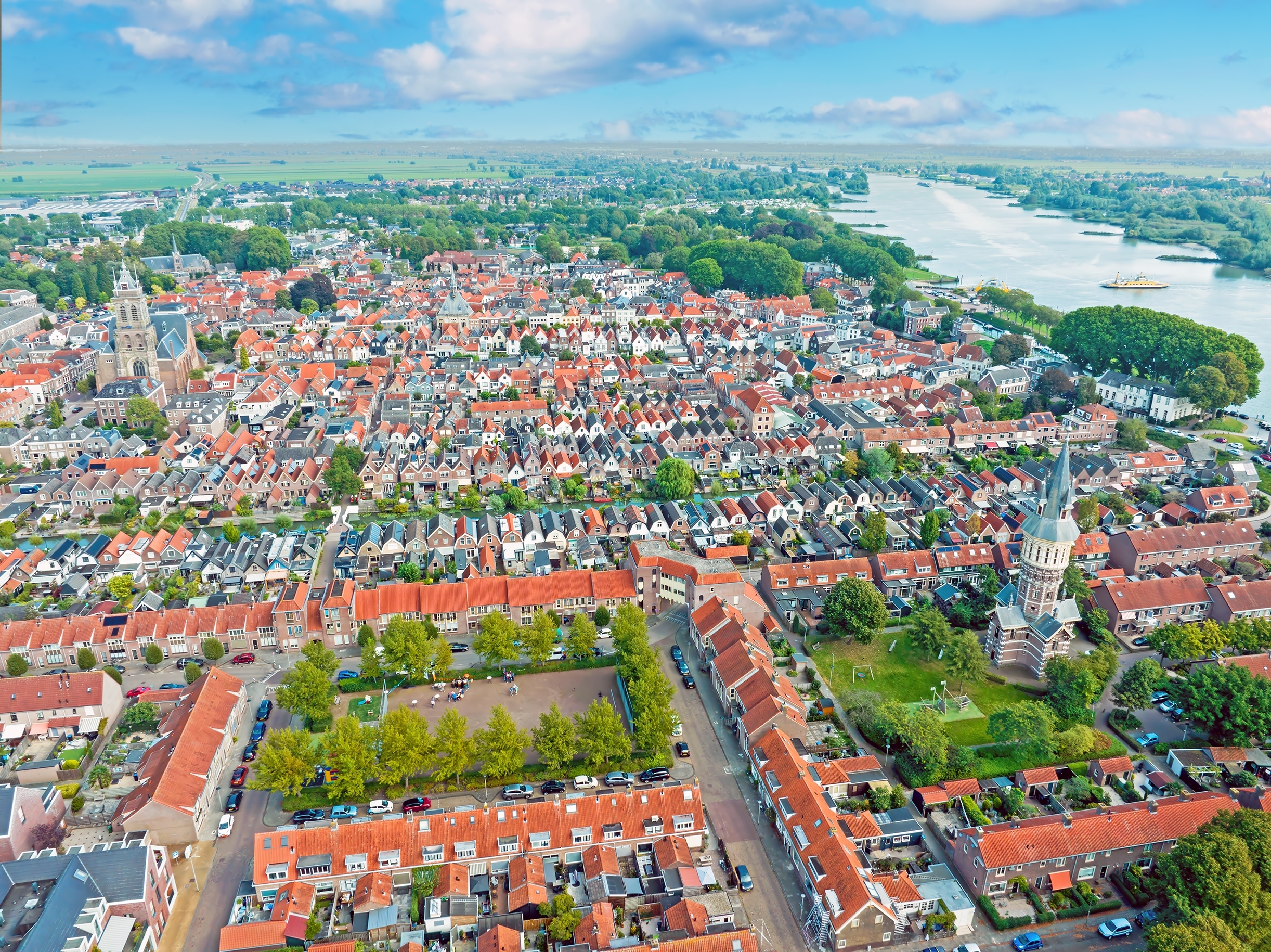 Fugleperspektiv over pittoresk hollandsk by med røde tage, kirke og maritim atmosfære