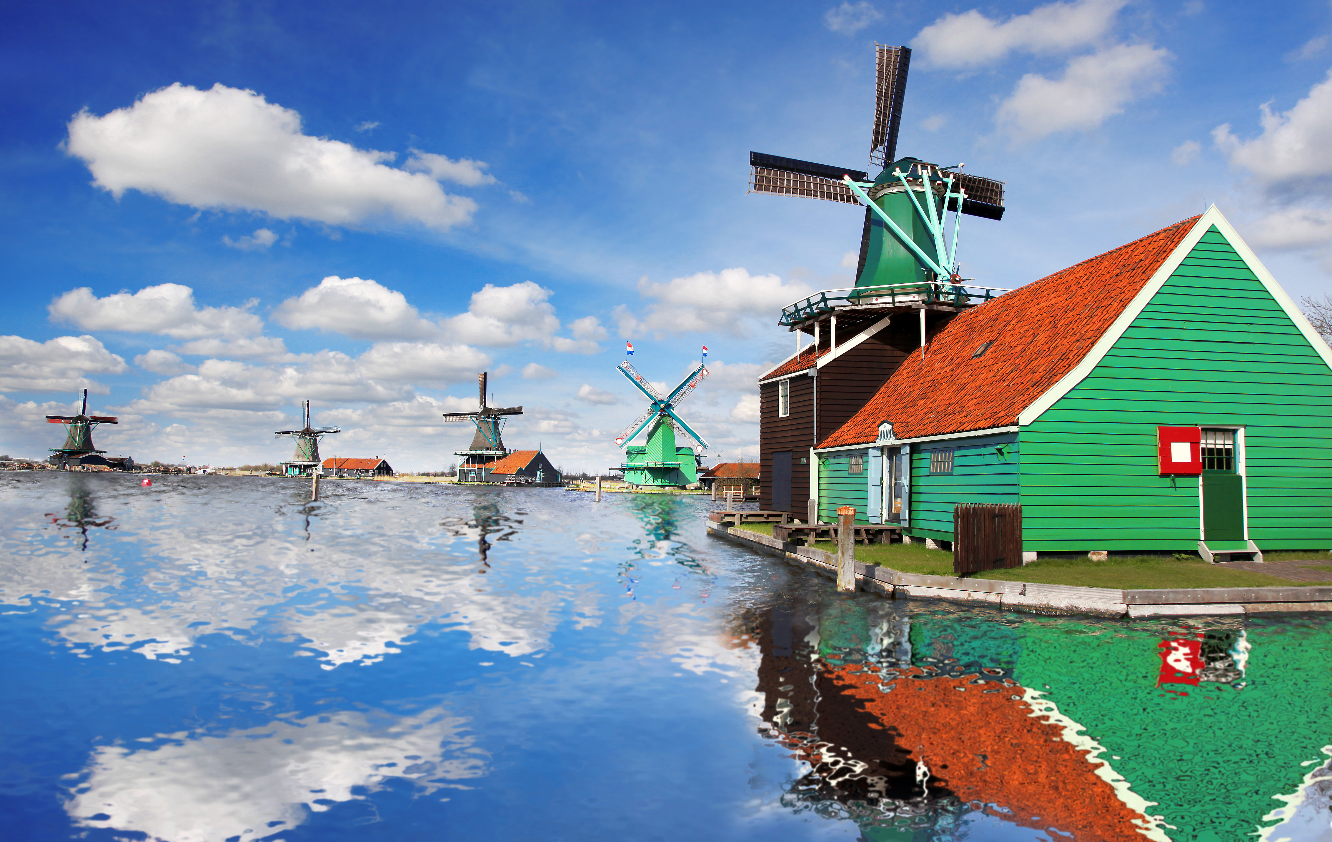 Ikoniske hollandske vindmøller og museumsby med refleksioner i stille vand