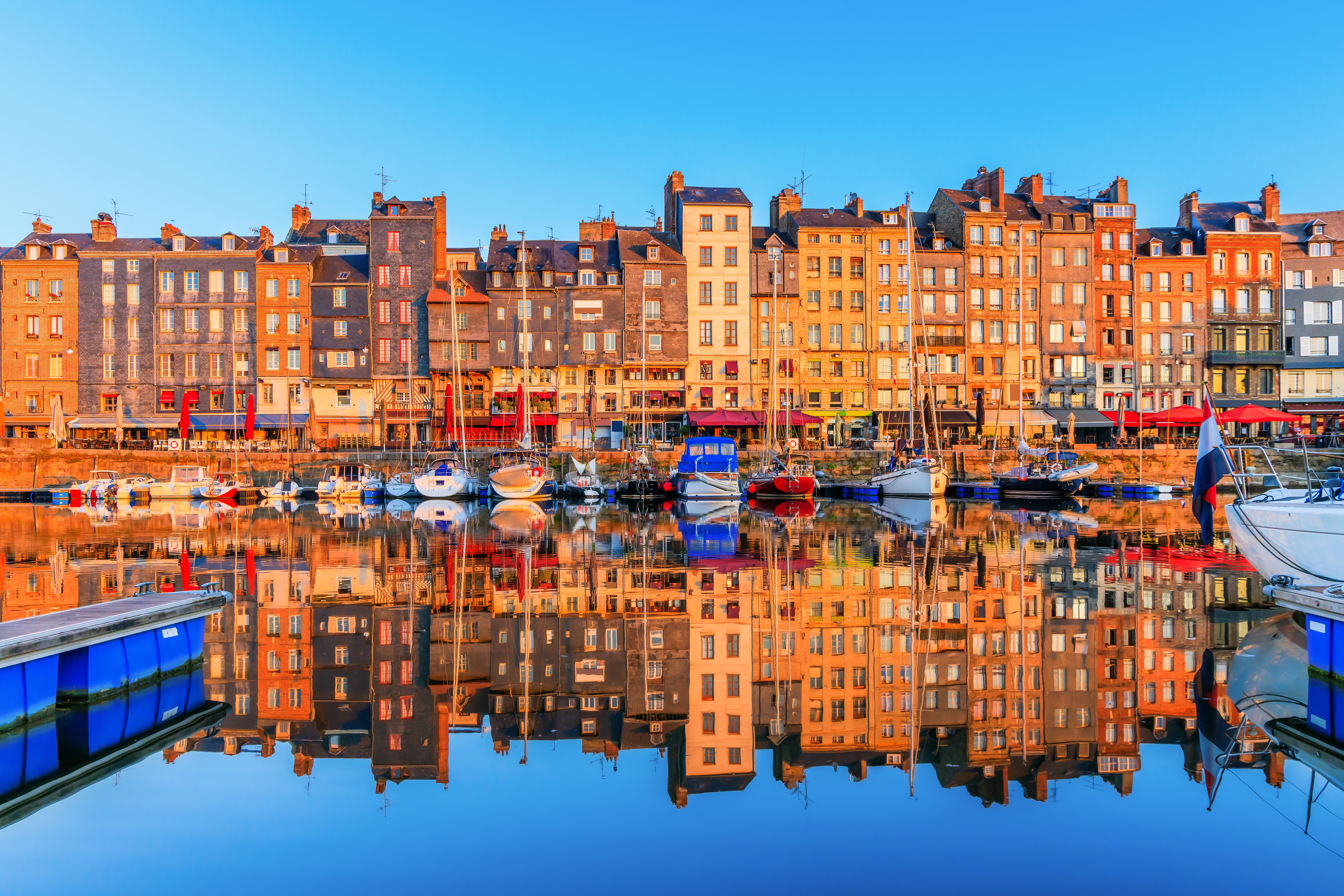 Pittoresk Honfleur havn i Normandiet med både og farverige huse i solnedgangslys