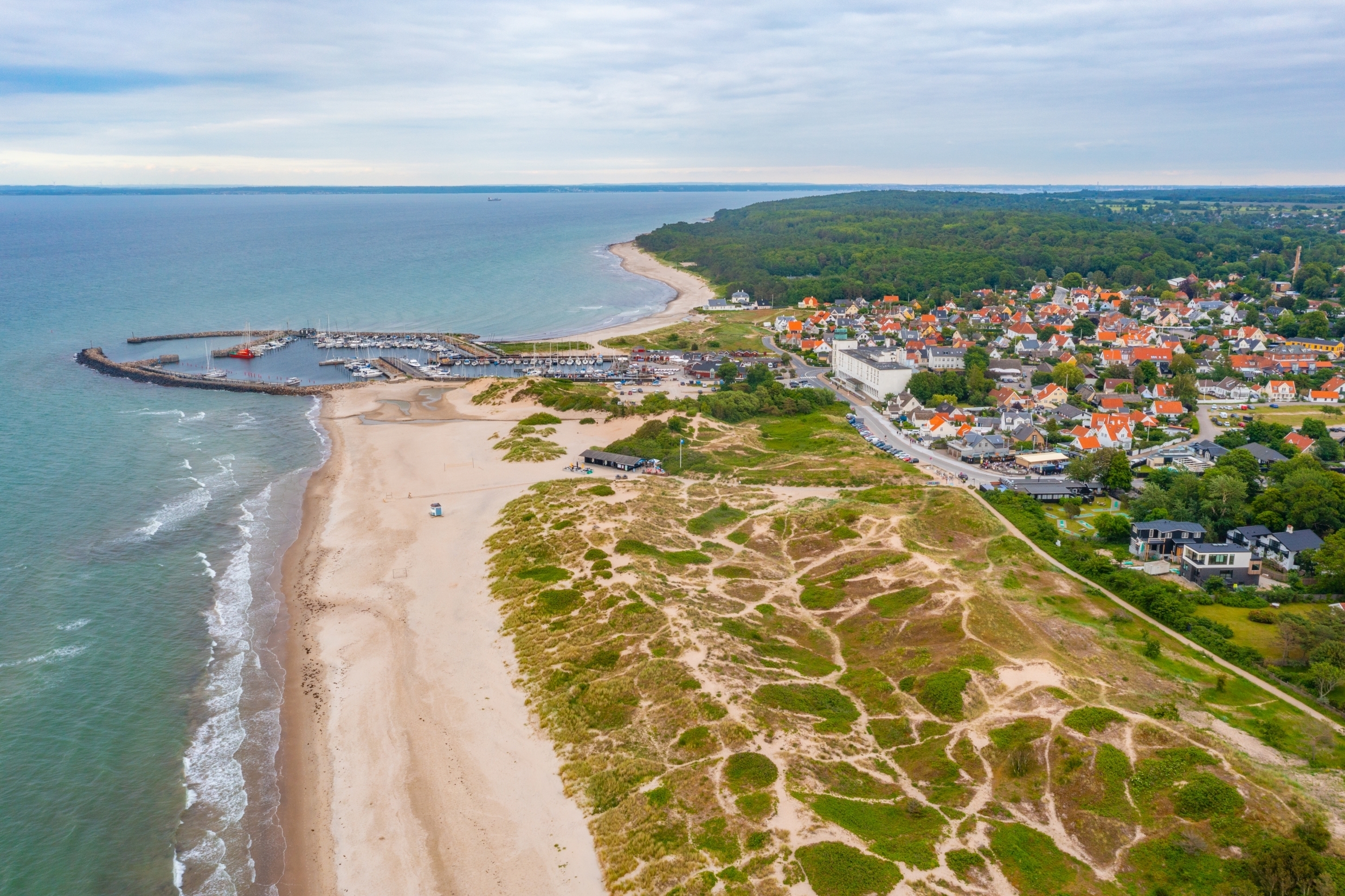 Fugleperspektiv over Hornbæk med sandklitter, lystbådehavn og charmerende kystby ved Kattegat på Sjælland