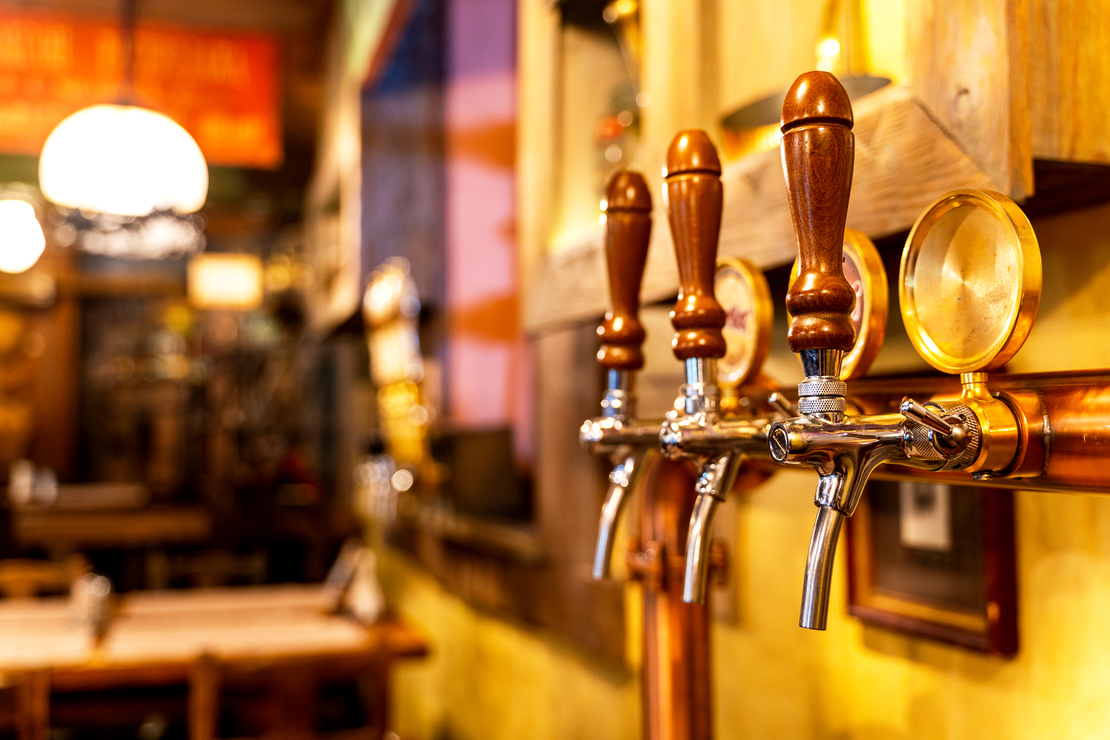 Hyggelige ølhaner i træ på en stemningsfuld pub-bar med varm og rustik indretning