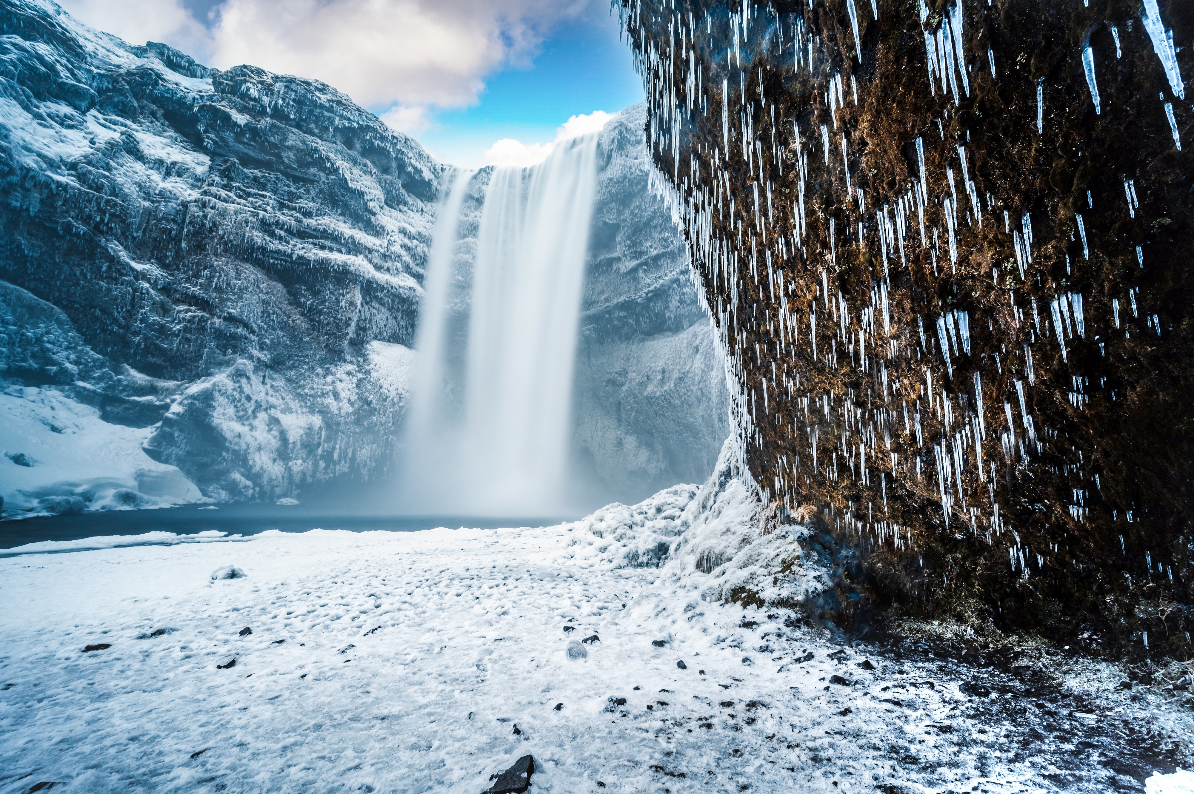 Skogafoss vandfald i Island med vinteris og snedækkede bjerge