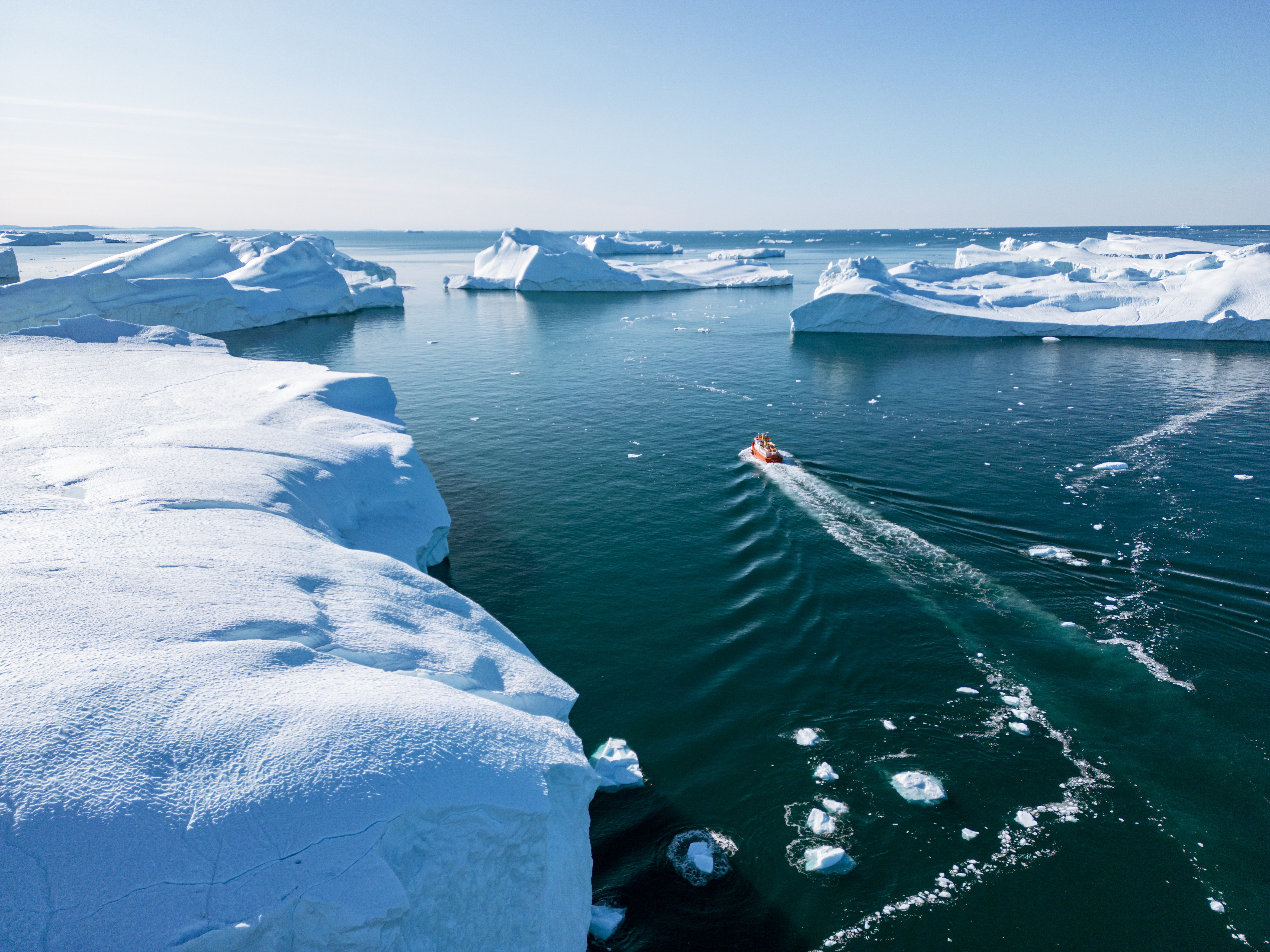 Dramatisk luftbillede af de massive isbjerge i Ilulissat Isfjord, hvor gletsjeren møder havet i Diskobugten - et unikt indblik i Grønlands mest berømte naturattraktion