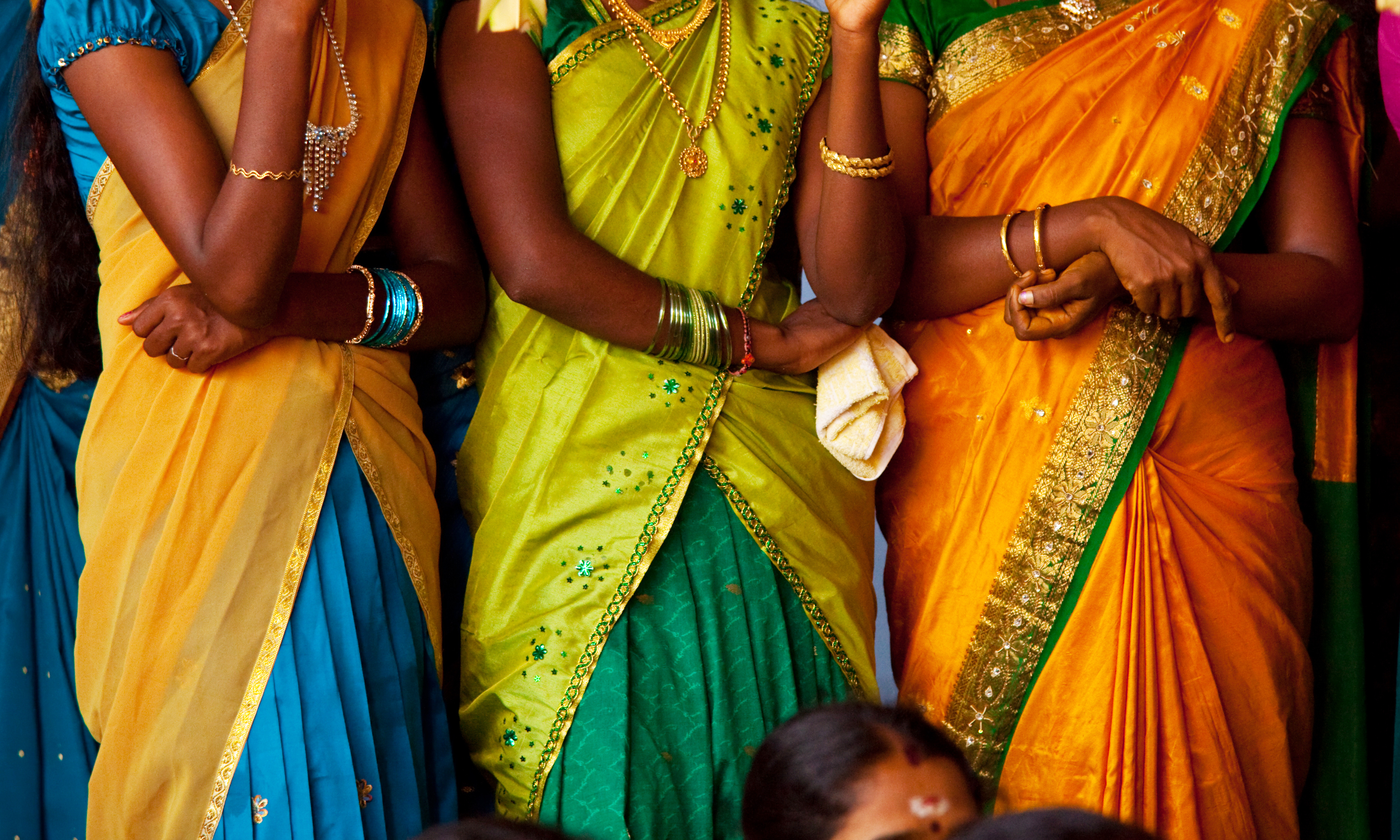 Smukke farverige traditionelle indiske saris båret af kvinder ved kulturel begivenhed i Indien
