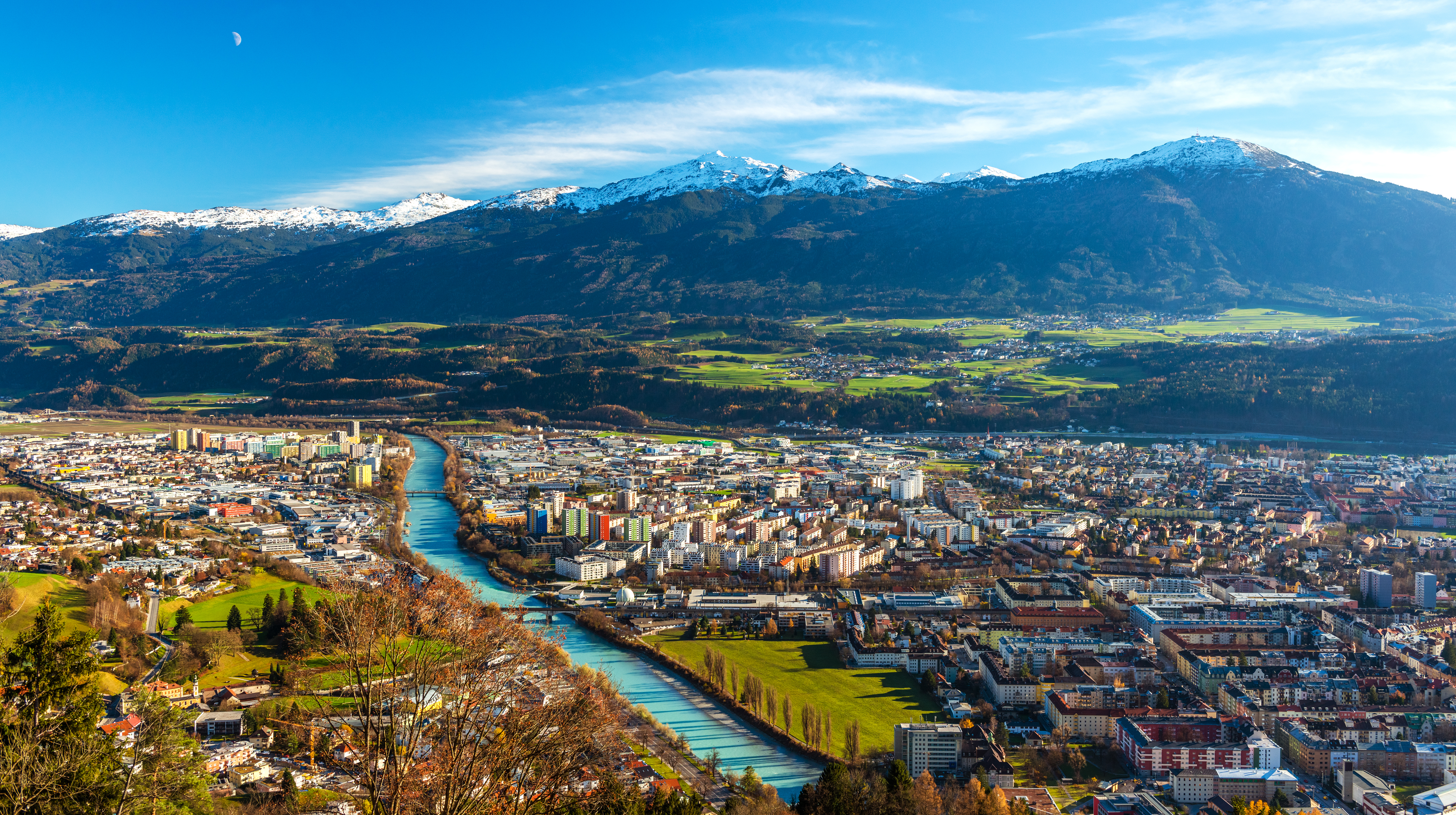 Fascinerende fugleperspektiv over Innsbruck by med de snedækkede alper i horisonten og Inn-floden der skærer gennem den idylliske tyrolske hovedstad