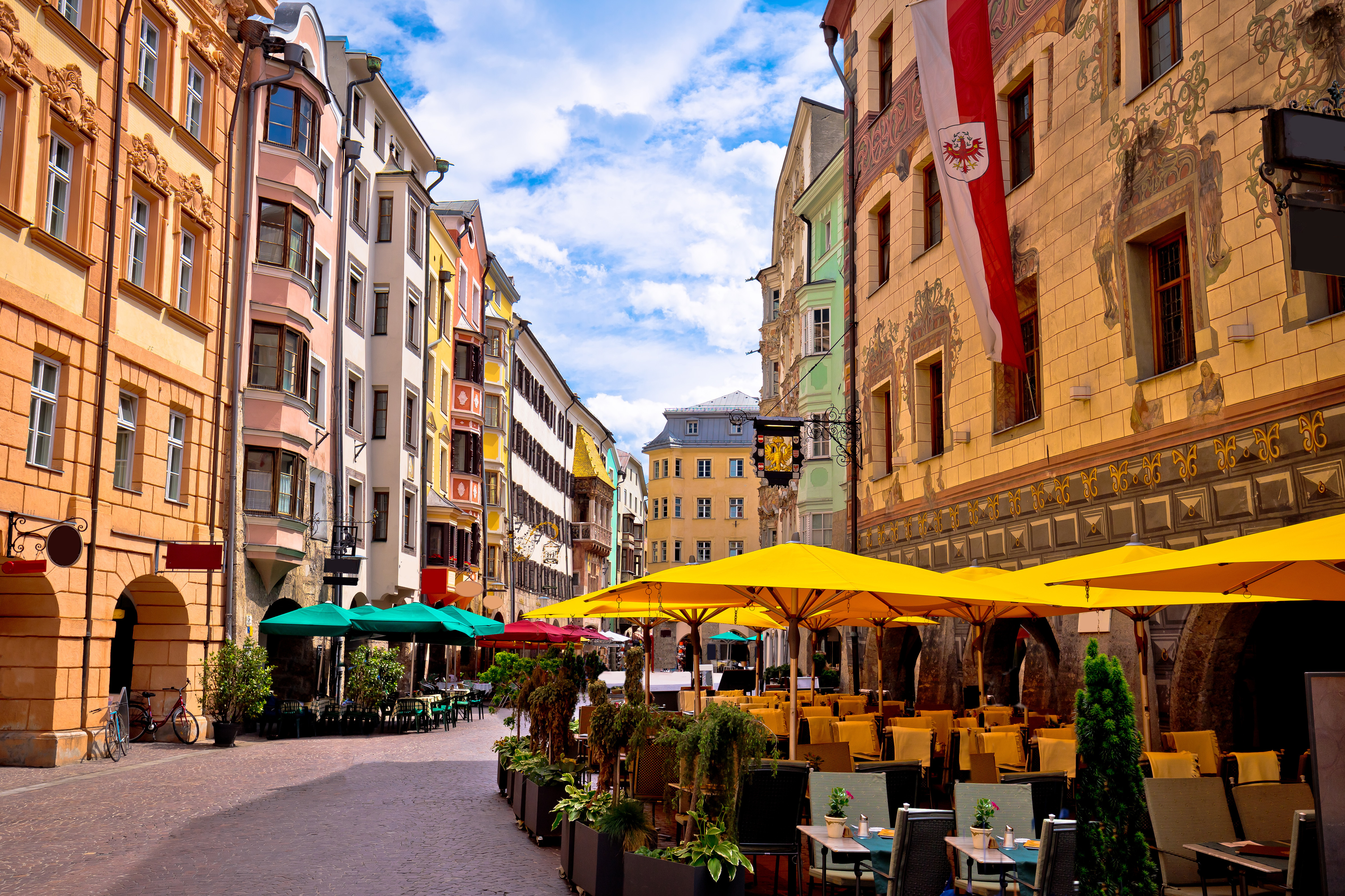 Stemningsfuld udsigt over Innsbrucks gamle bydel med farverige bygninger og de imponerende alper, der omkranser den østrigske by i Tyrol